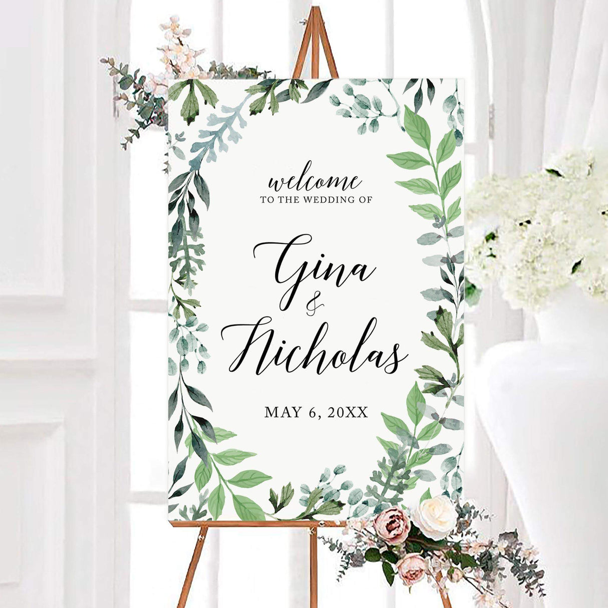 Watercolor oval greenery wedding welcome sign with eucalyptus-style leaves framing personalized couple names in elegant black script. The botanical design includes a custom wedding date on a clean white background.