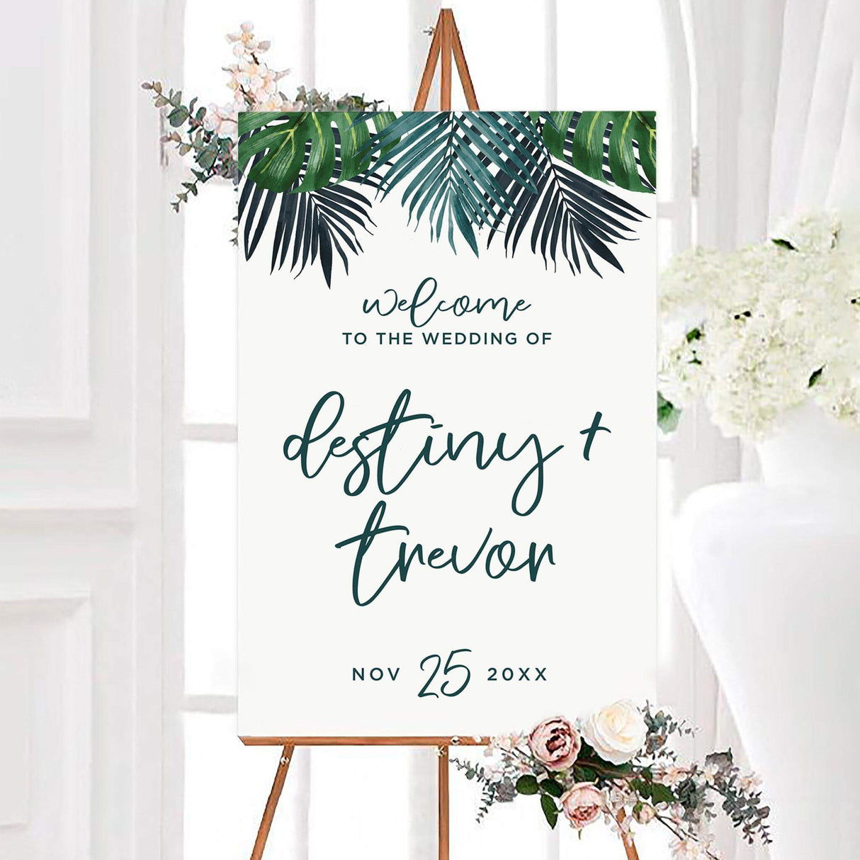 Tropical palm fronds wedding welcome sign featuring watercolor palm fronds and lush green leaves across the top. The personalized design includes the couple’s names and wedding date in modern script lettering.