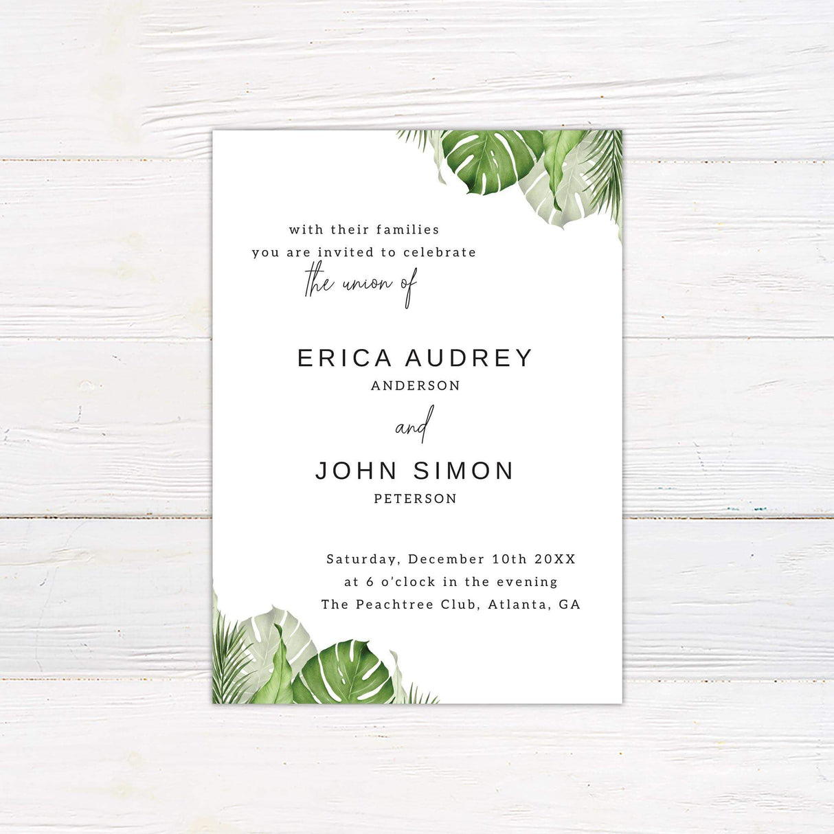 Minimalist wedding invitation with green watercolor palm and monstera leaves, modern serif and script fonts on white background.
