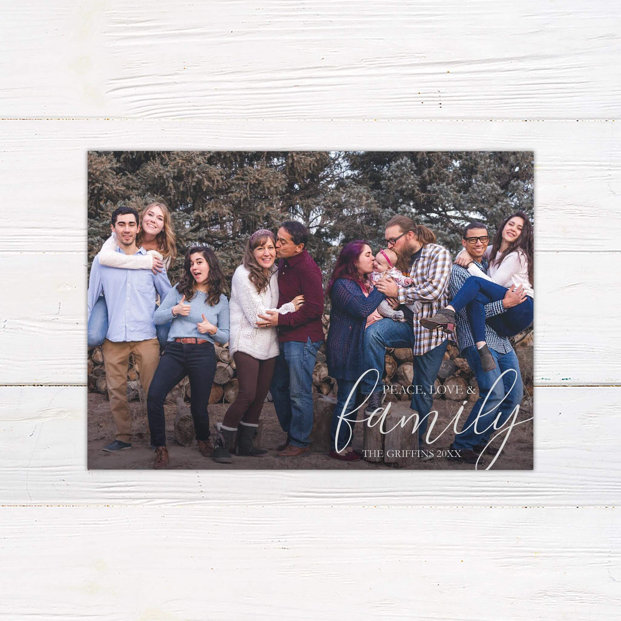 A holiday card design that uses a full photo layout with the words "Peace, Love & Family" written in elegant script. The design emphasizes warmth and togetherness.