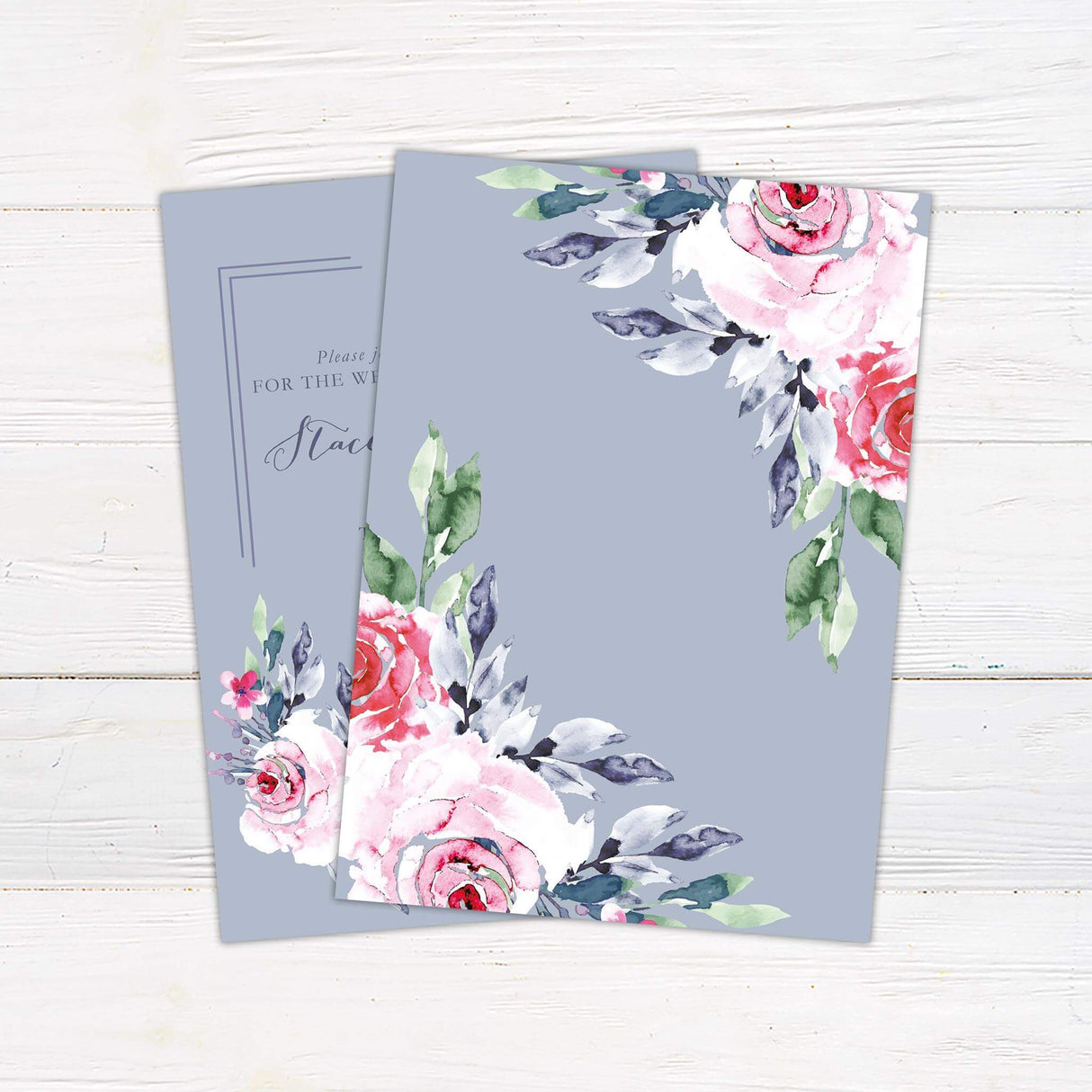 Wedding invitation with watercolor pink and red roses, greenery, and script text on a dusty periwinkle blue background.= bak side
