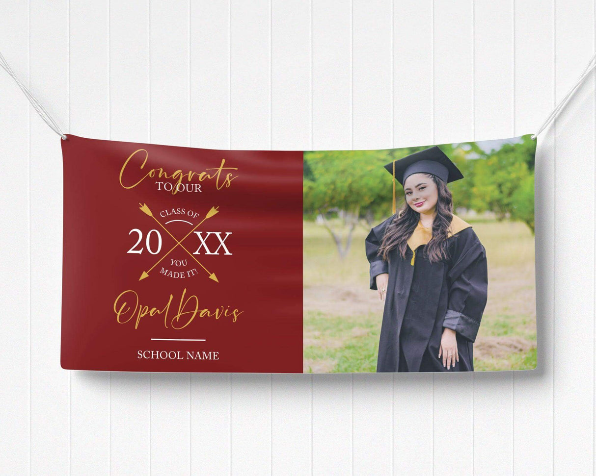 Graduation vinyl banner with split design featuring bold congratulatory text, crossed arrow class year emblem, and a custom graduate photo. Perfect for high school, college, or university graduation parties and ceremonies. Durable, weatherproof, and available in custom colors for a standout celebration. red and gold