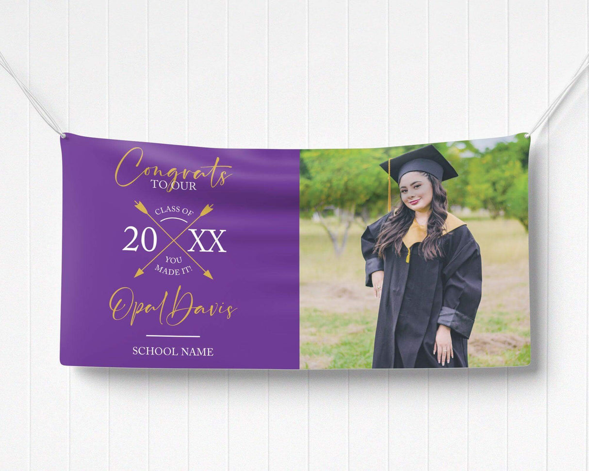 Graduation vinyl banner with split design featuring bold congratulatory text, crossed arrow class year emblem, and a custom graduate photo. Perfect for high school, college, or university graduation parties and ceremonies. Durable, weatherproof, and available in custom colors for a standout celebration. purple and gold