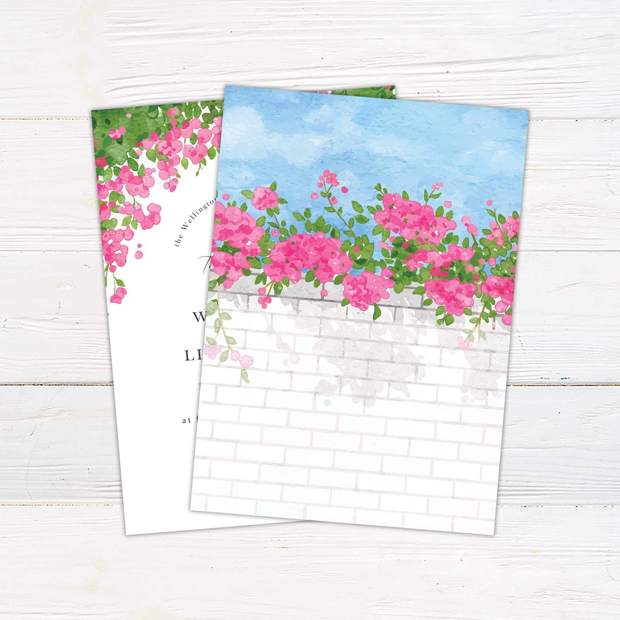 Wedding invitation with bright pink watercolor floral arch, greenery, and elegant serif and script fonts on a white background.- back side