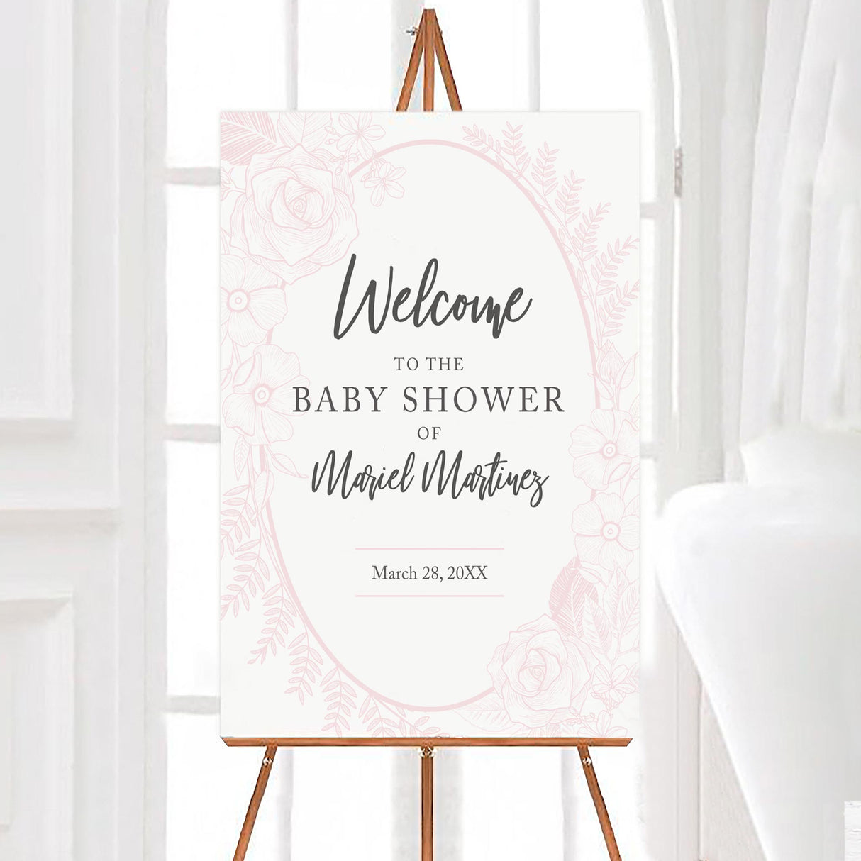 A pink floral baby shower welcome sign with a soft pink floral oval frame on a white background. The design features delicate flowers and clean typography.
