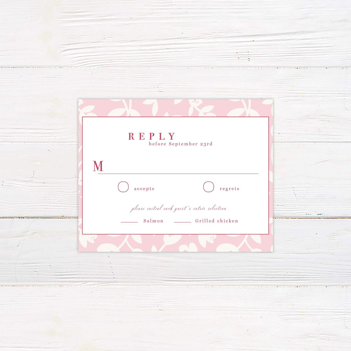 RSVP card with blush pink floral vine border and coordinating red serif and script fonts.