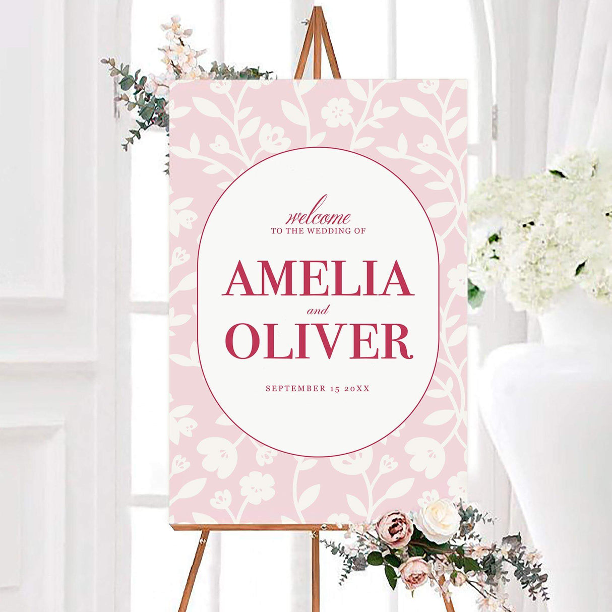 Pink garden wedding welcome sign with an ivory floral pattern, white oval center, and personalized rose-pink lettering. The design features the couple’s names and wedding date in elegant typography.