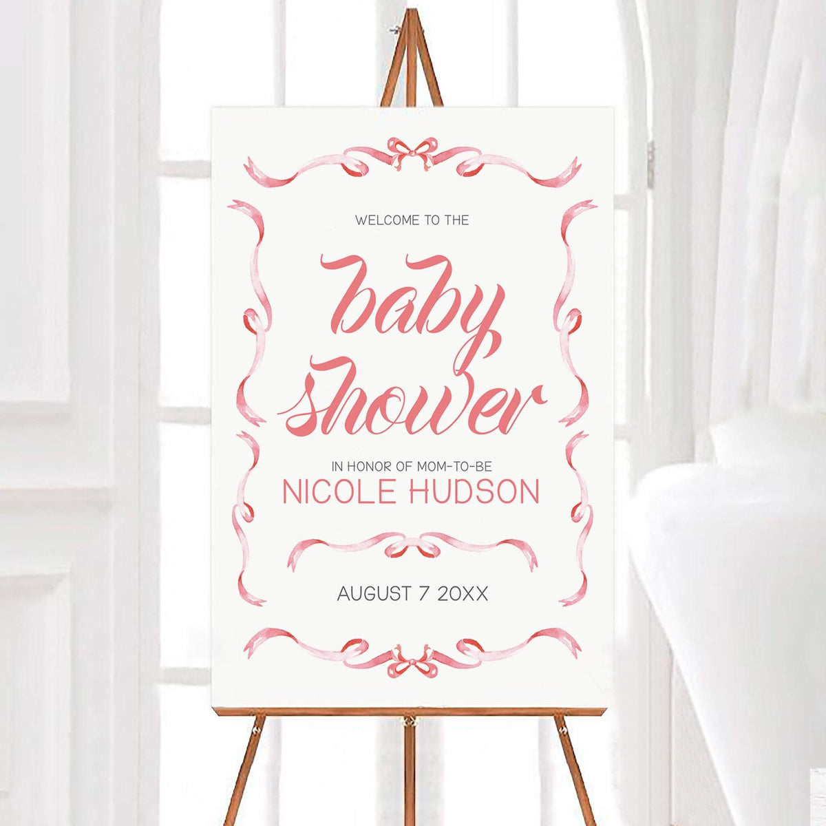 Personalized elegant ribbons baby shower welcome sign featuring delicate pink watercolor ribbons and bows forming an elegant decorative border around pink script lettering. The white background design includes customizable names and an event date.