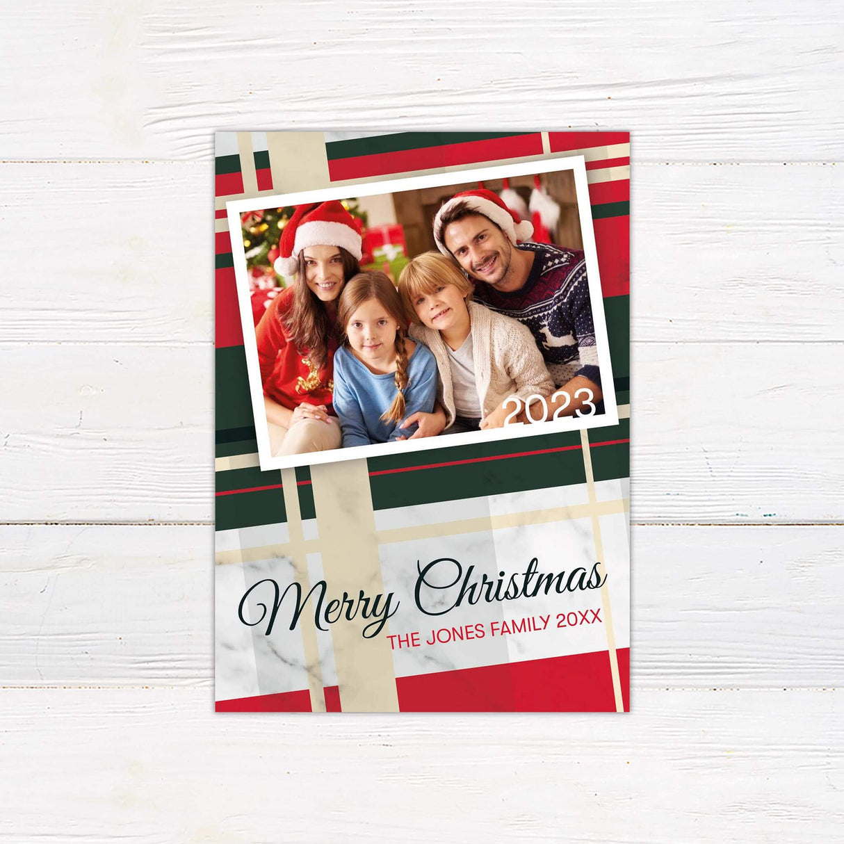 A plaid holiday card design with red and green patterns and a photo frame for a family picture. The layout highlights a classic and festive Christmas style.