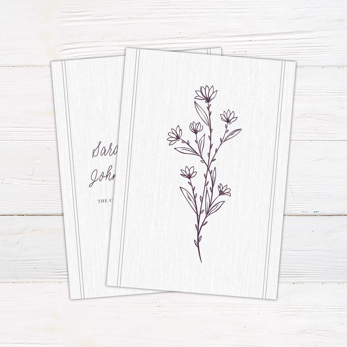 Wedding invitation with plum floral sprig monogram, handwritten script and serif fonts, and soft linen textured background.- back side