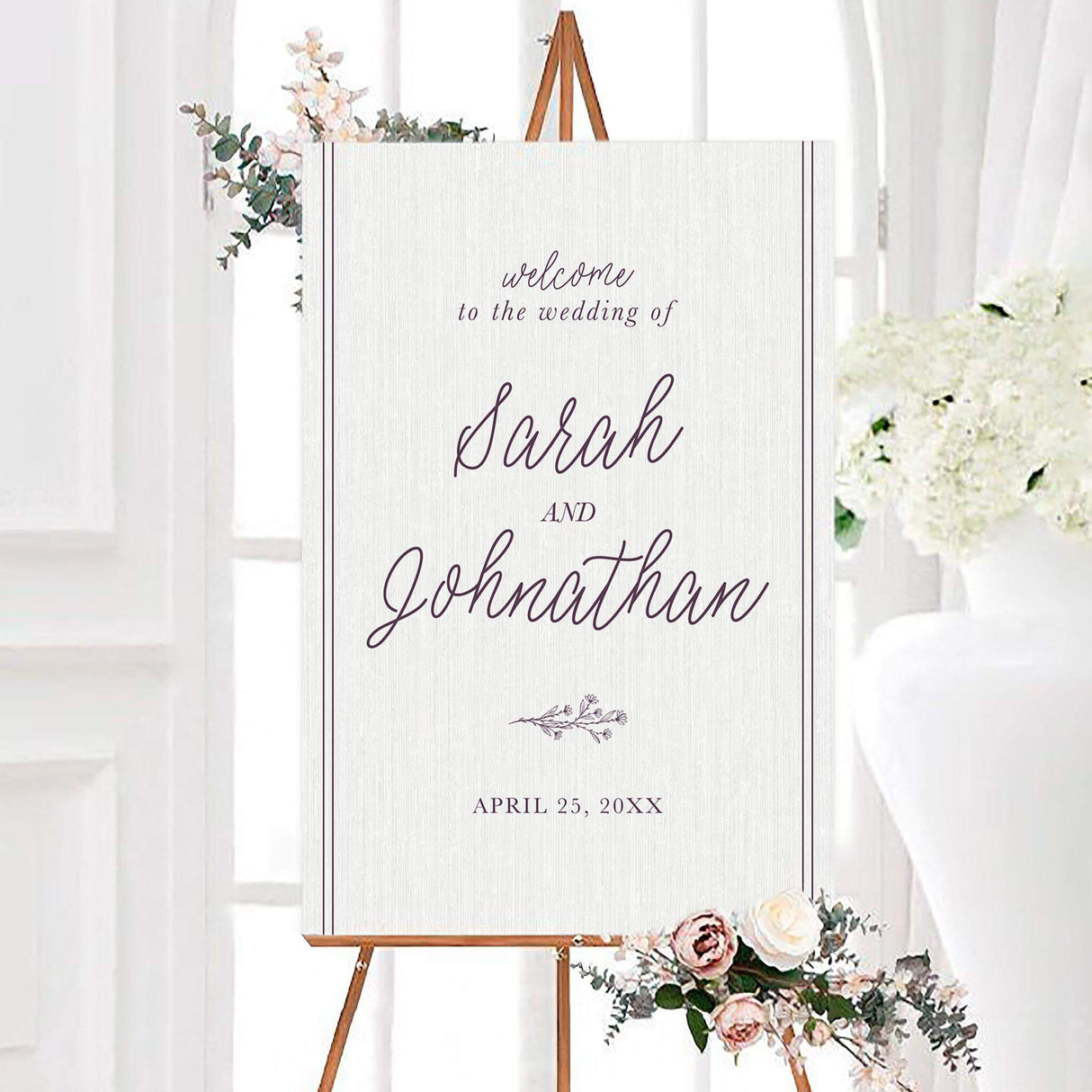 Elegant plum sprig wedding welcome sign with flowing script names, a subtle white woodgrain background, and a small botanical sprig. Personalized wedding date appears beneath the minimalist botanical design.