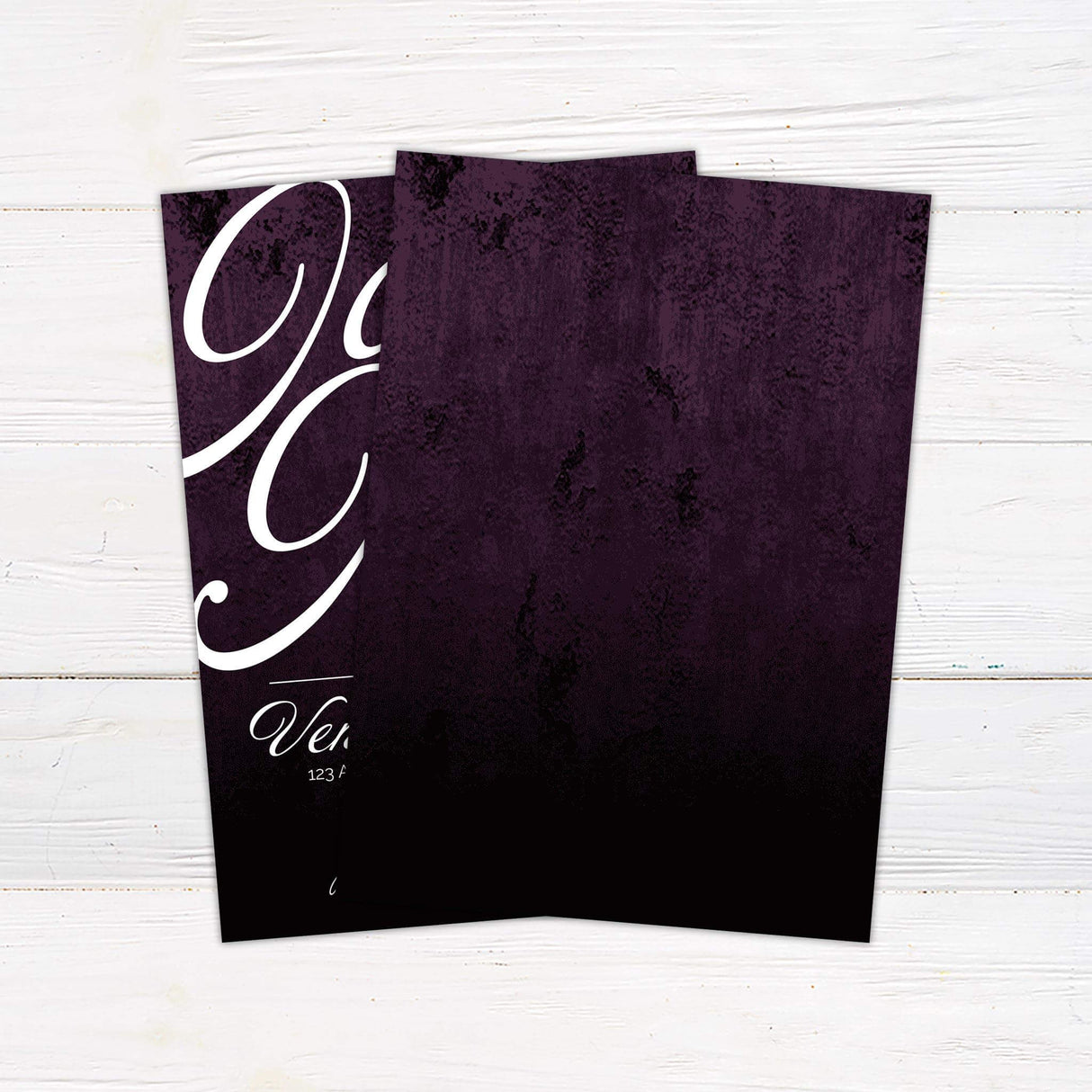 Wedding invitation with oversized white script on deep plum background, modern layout, and elegant serif and cursive fonts.- back side