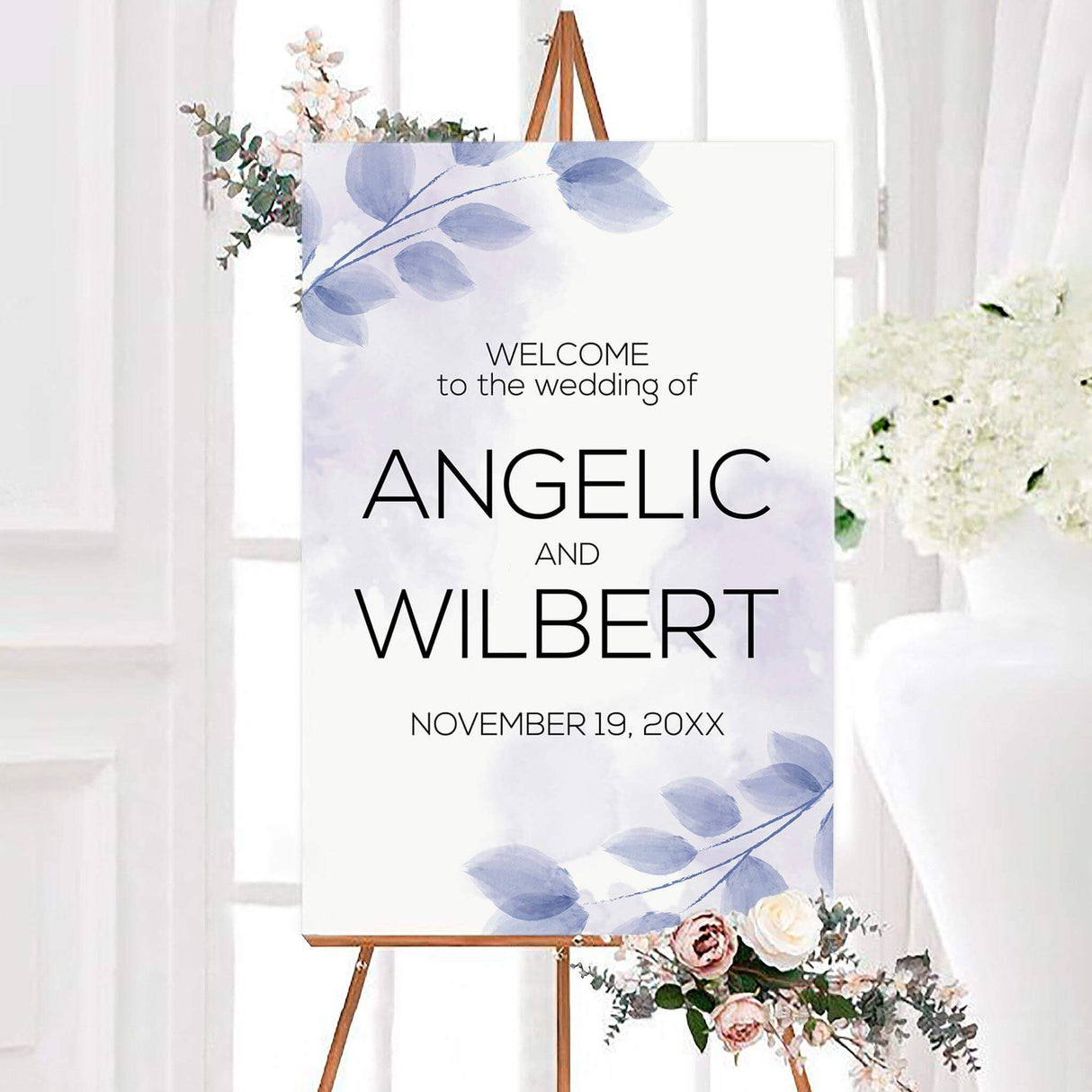 Purple leaves wedding welcome sign featuring soft lavender and blue leafy branches on a white background. Modern black typography displays the couple’s names and personalized wedding date.