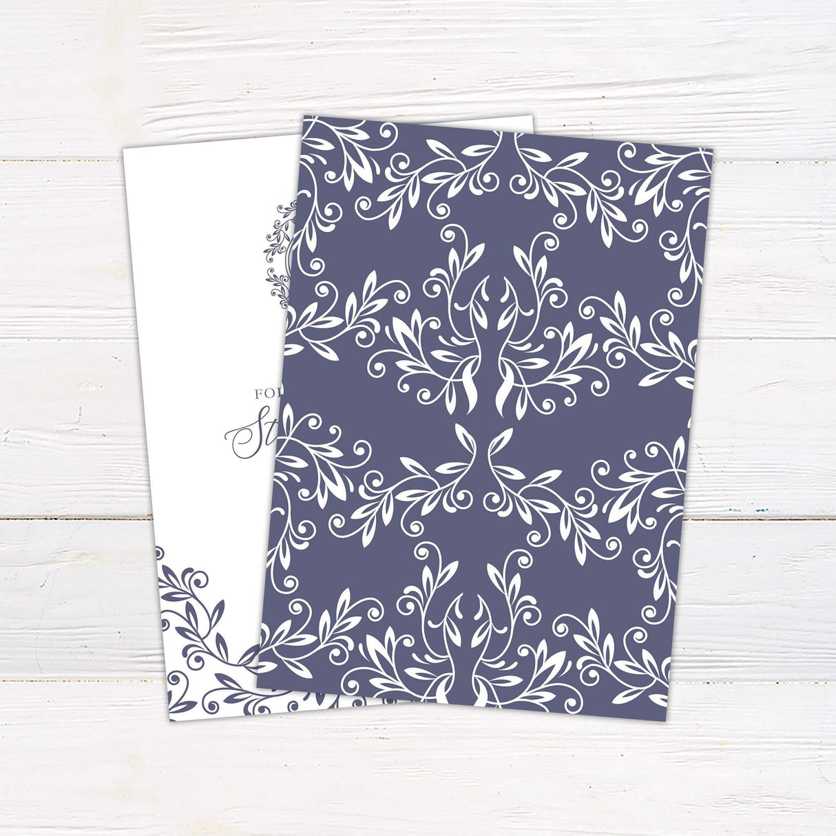 Elegant wedding invitation with monogram crest, lavender scroll flourishes, and serif and script fonts on a white background.- back side