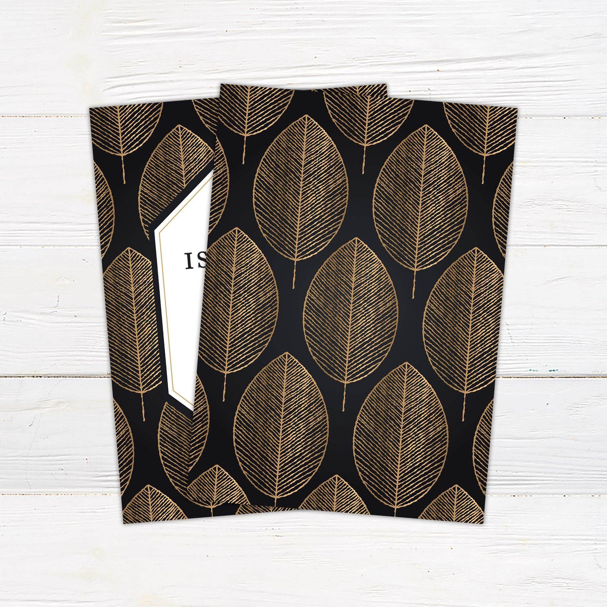 Wedding invitation with black background, gold leaf pattern, geometric white center panel, and elegant serif and script fonts.- back side