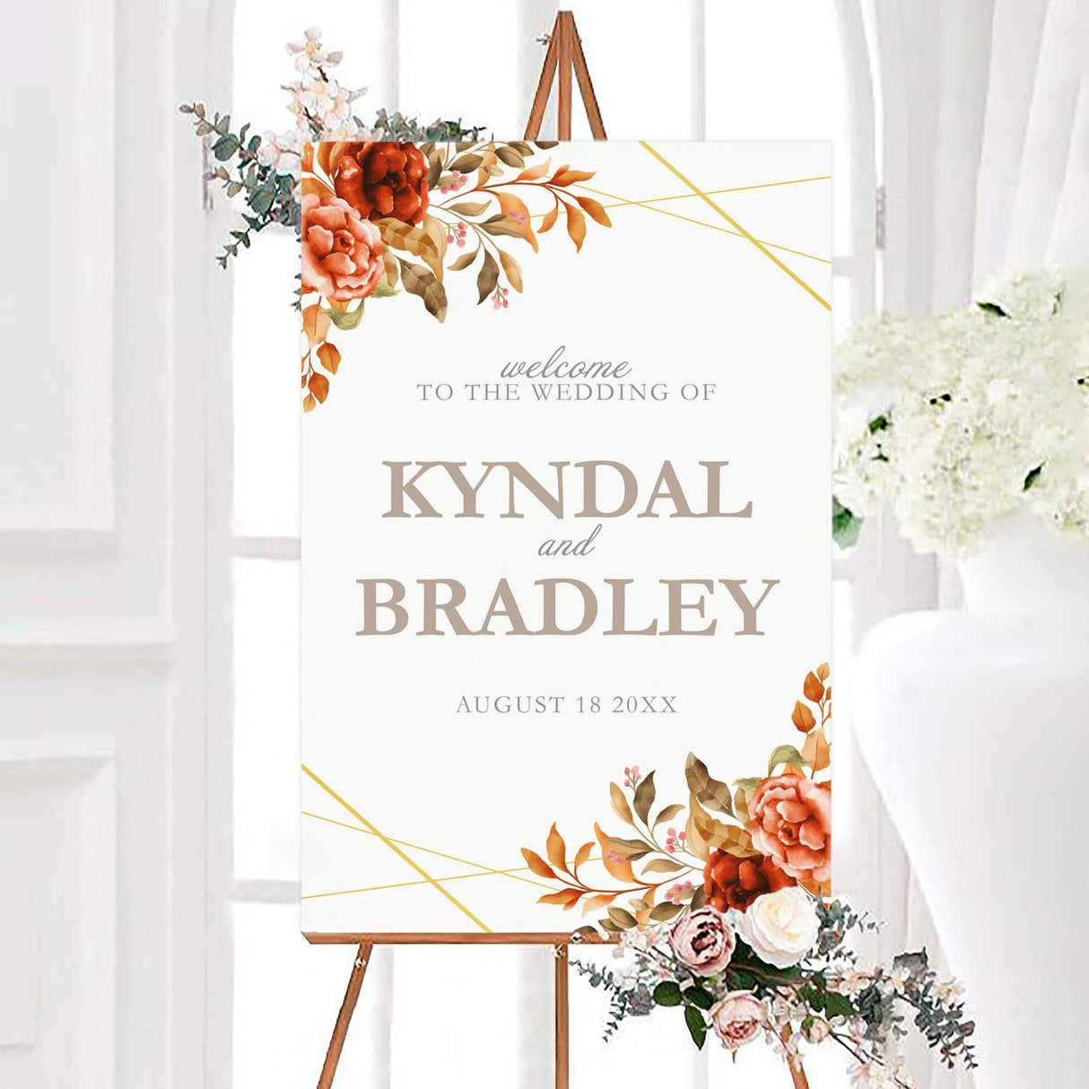 Rich autumn floral wedding welcome sign with burnt orange and red watercolor roses, warm foliage, and gold geometric corner accents. The white sign features personalized couple names and a wedding date in elegant neutral typography.