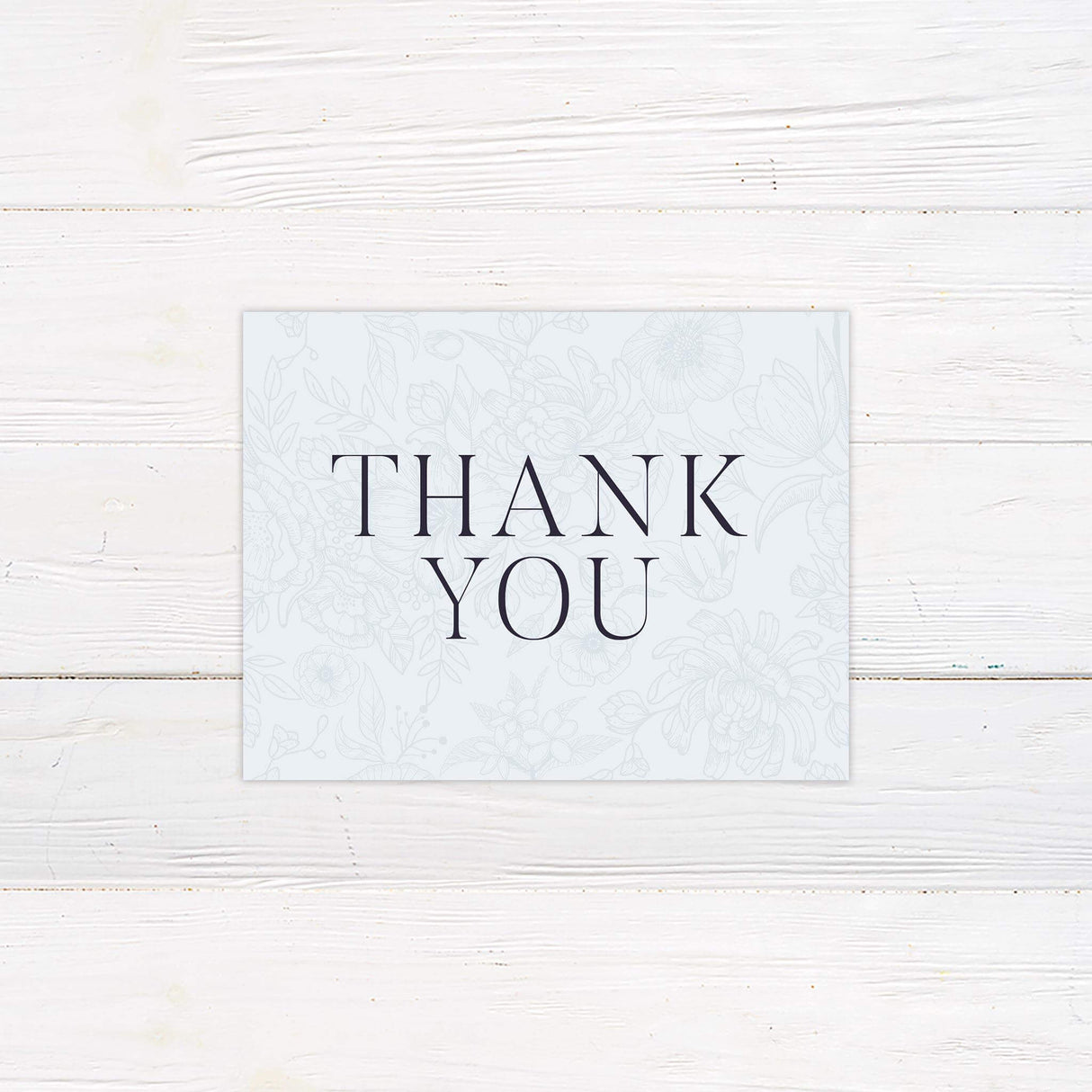 Coordinating thank you card featuring light blue floral sketch background and black script message for heartfelt post-wedding notes.