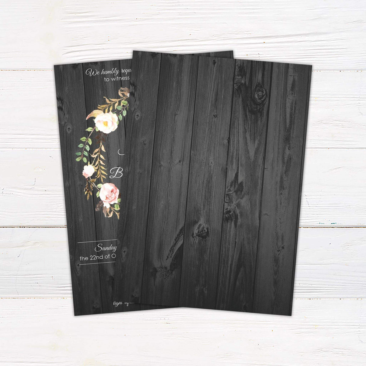 Rustic wedding invitation with floral rose wreath on a dark wood background and elegant white script and serif fonts for a country-themed celebration.- back side