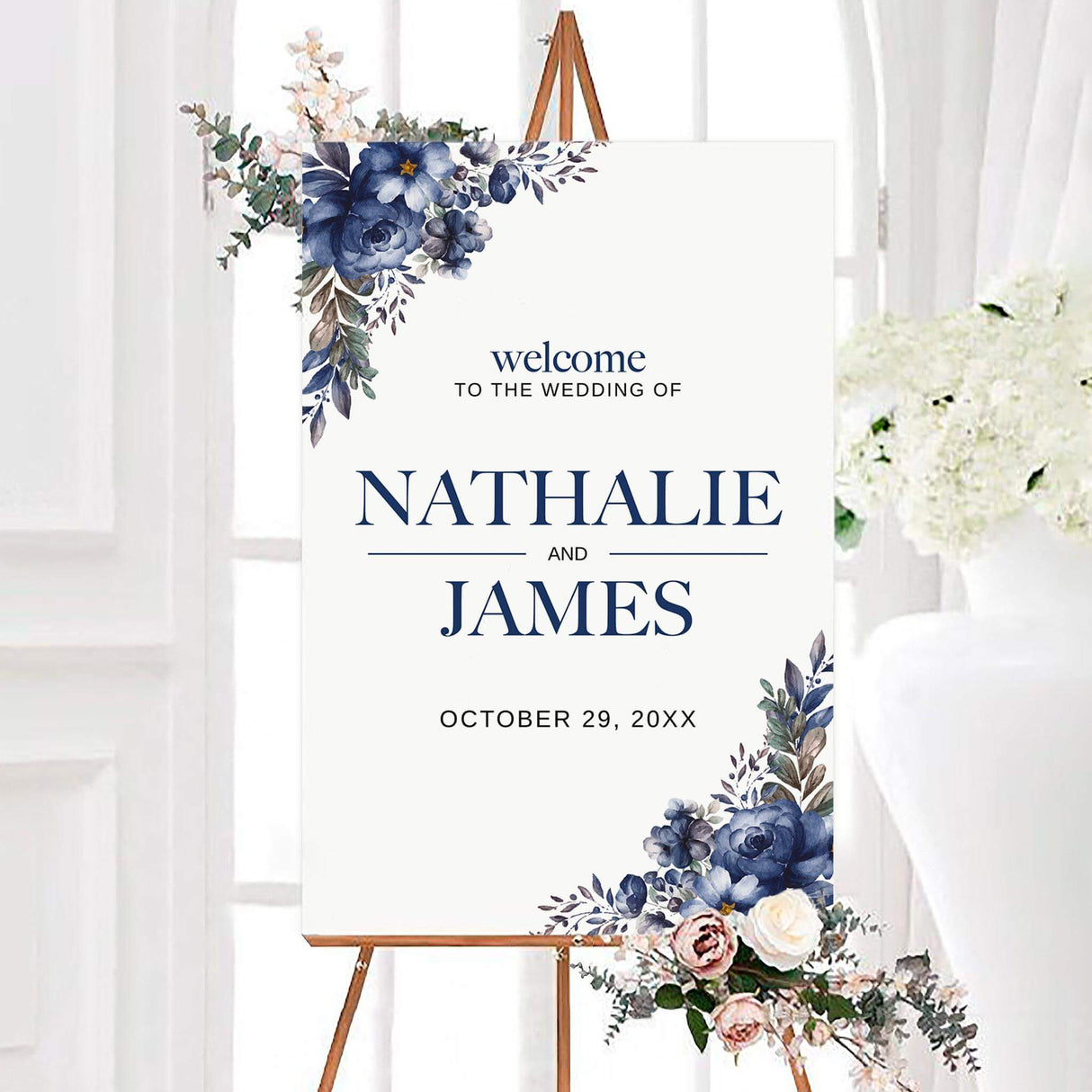 Roses and leaves wedding welcome sign featuring blue roses, botanical leaves, personalized couple names, and a wedding date. Floral arrangements decorate the upper-left and lower-right corners of the white design.