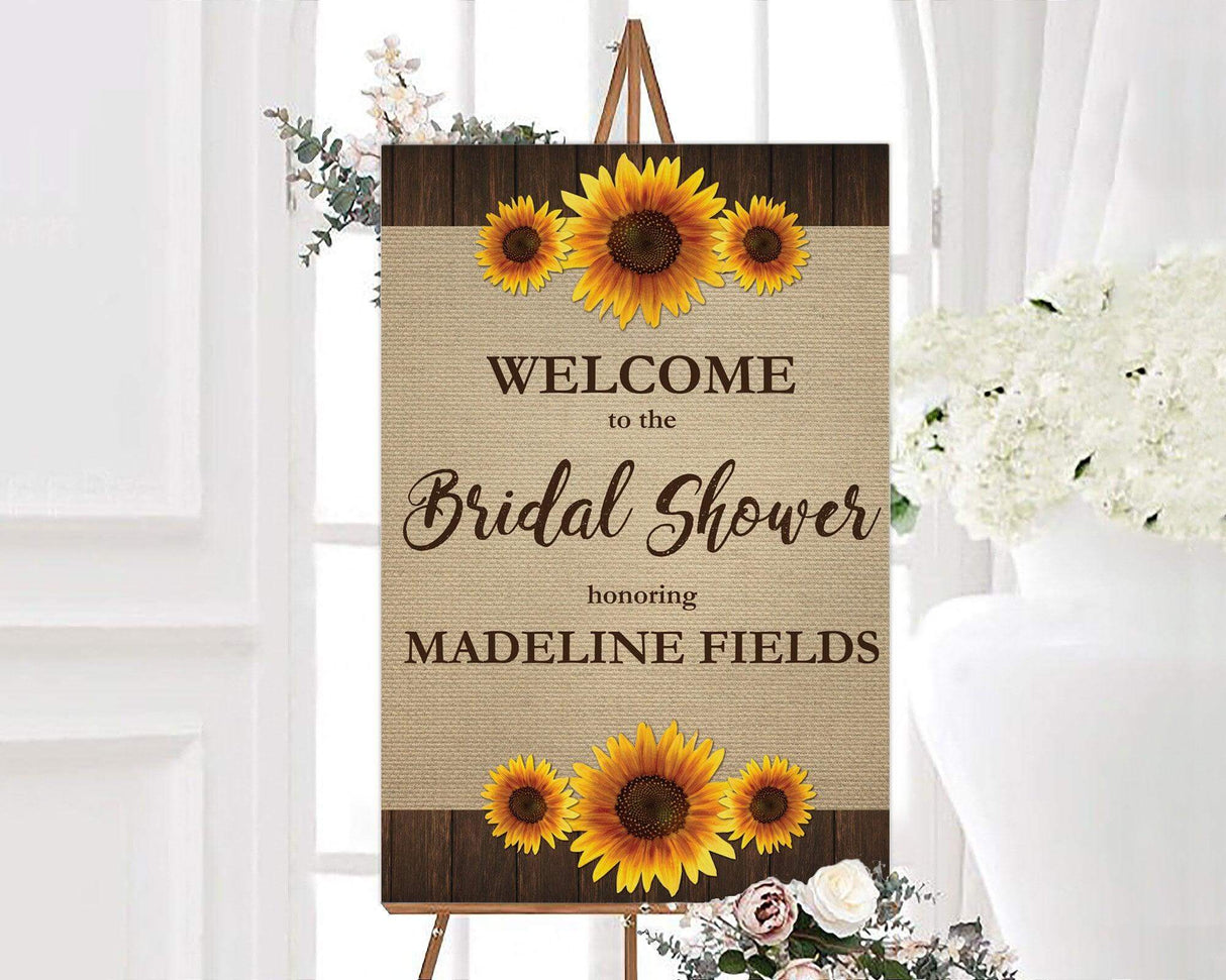 A rustic sunflower bridal shower sign with sunflowers on a burlap background. The design features floral artwork and natural textures.