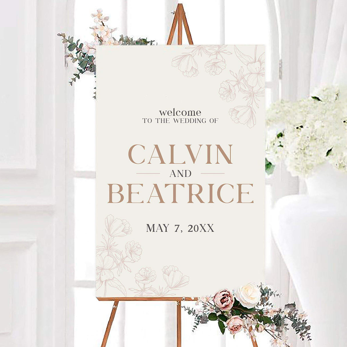 Neutral sandrift floral wedding welcome sign with sand-colored serif lettering and delicate blush botanical line art on an ivory background. The personalized design features the couple’s names and wedding date.