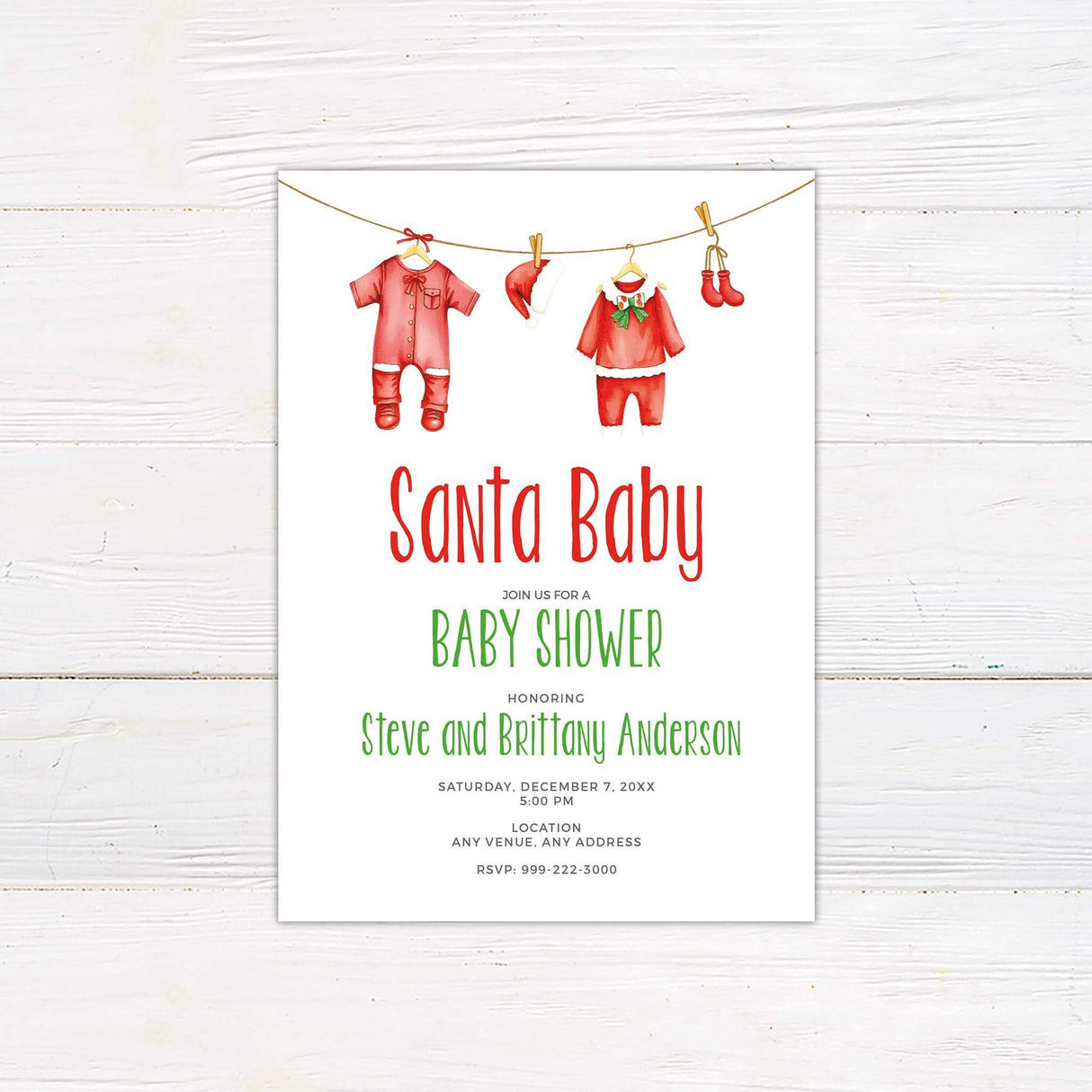 Santa Baby baby shower invitation with red and green festive theme featuring baby clothes and event details on a wooden background.