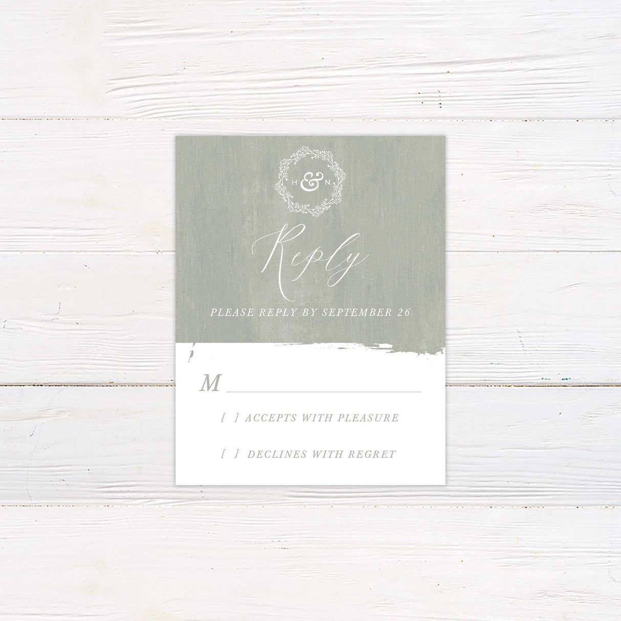 Sage green RSVP card with painted background, white script fonts, and coordinating monogram details.