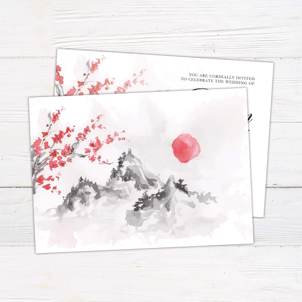 Wedding invitation with watercolor cherry blossom branches and misty gray mountain background, featuring script and serif fonts on white cardstock.- back side