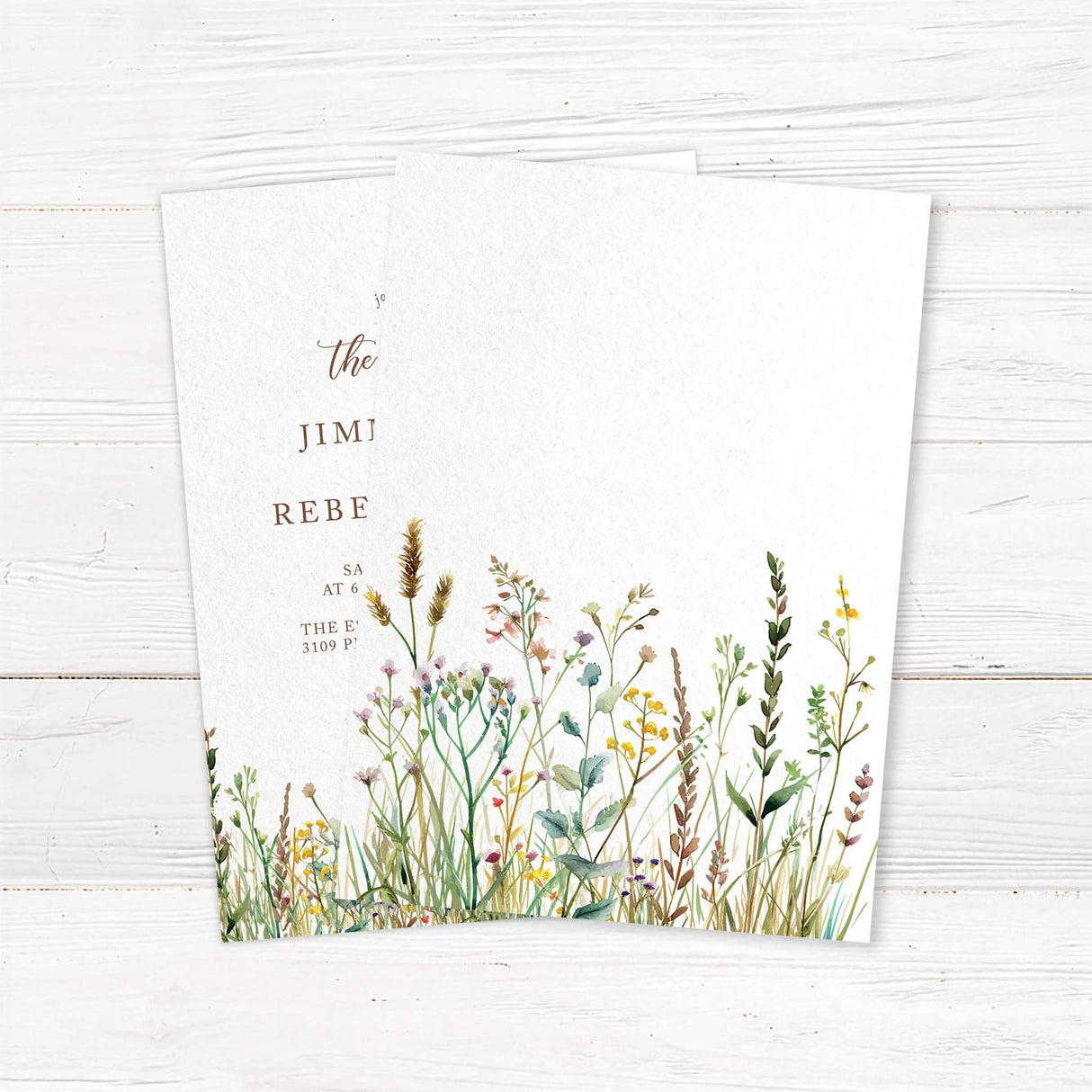 Elegant wedding invitation with a minimalist design featuring delicate script and serif fonts. The bottom of the invitation is adorned with a watercolor wildflower border, adding a rustic and romantic touch. The text includes event details such as the date, time, and venue, with a note about cocktails, dinner, and dancing to follow. The color palette consists of soft neutrals and earth tones, creating a timeless and sophisticated look. Back.