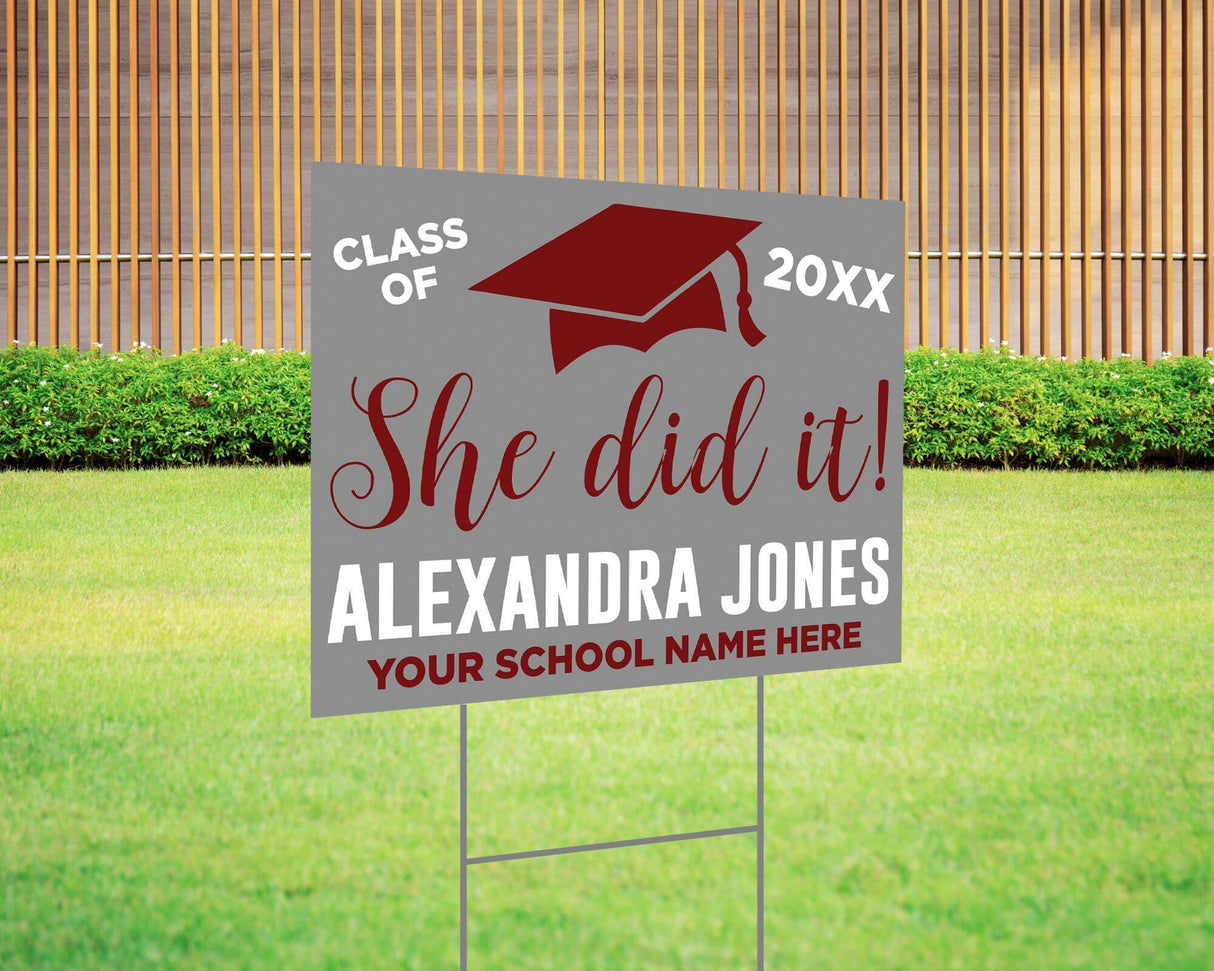 She Did It! graduation yard sign featuring a bold mortarboard cap, custom class year, and school name. Printed on durable Coreplast plastic, available in custom colors and single or double-sided print, perfect for high school and college graduates. Gray and Red