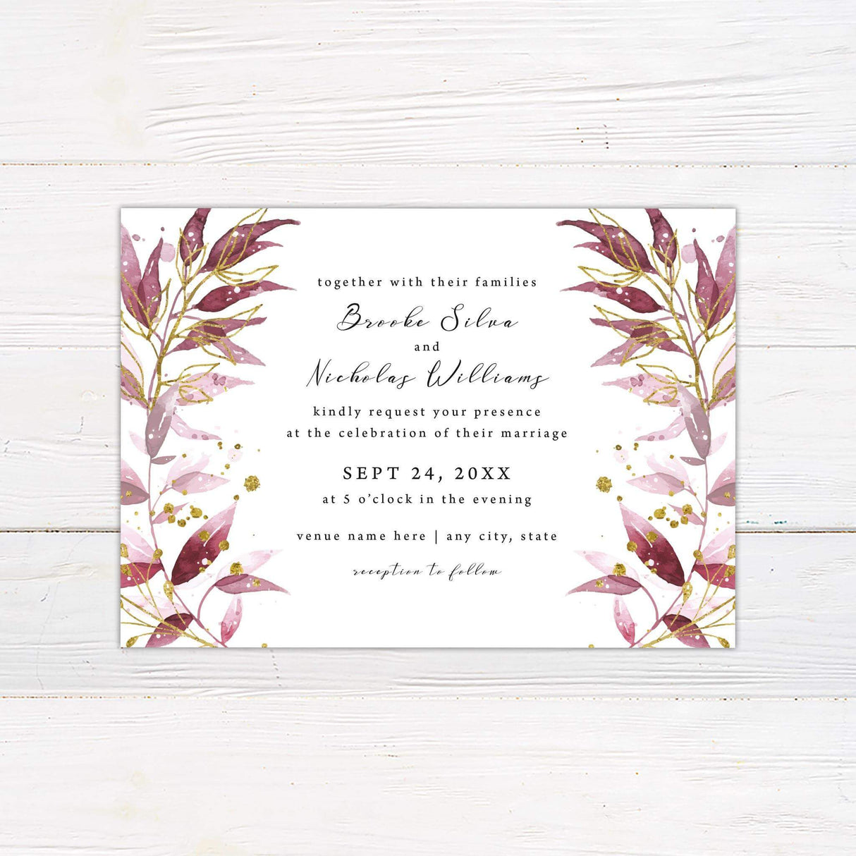 Wedding invitation with burgundy and blush watercolor leaves, gold botanical accents, and elegant script and serif fonts on white cardstock.