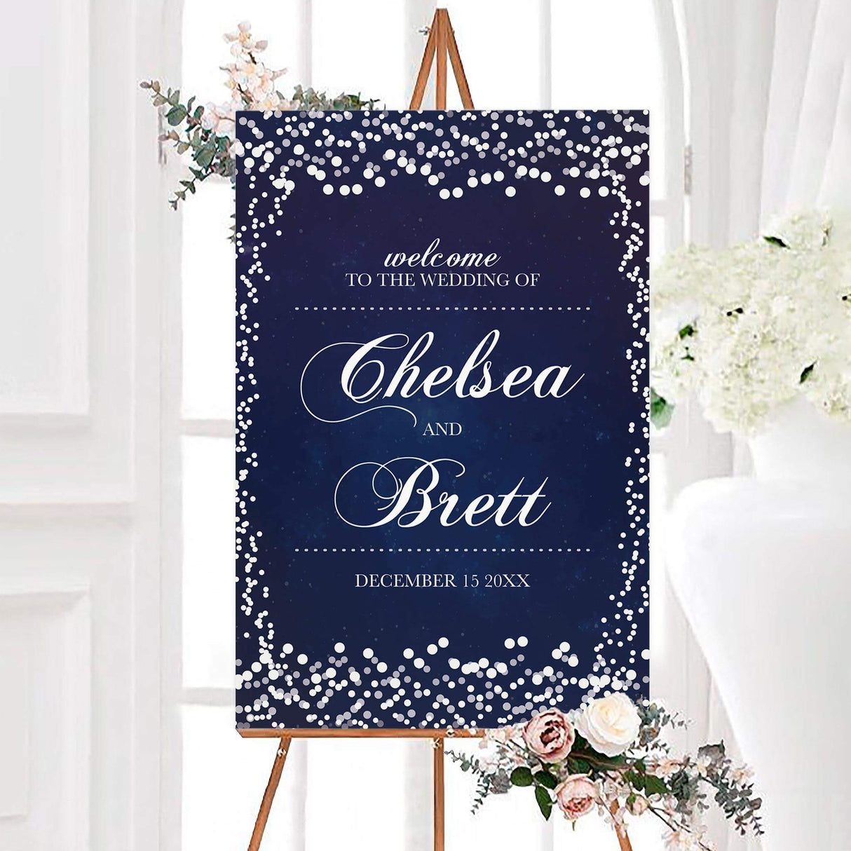 Navy blue silver glitter wedding welcome sign featuring elegant white calligraphy and personalized couple names. Silver and white glitter-style confetti surrounds the design with a sparkling border.