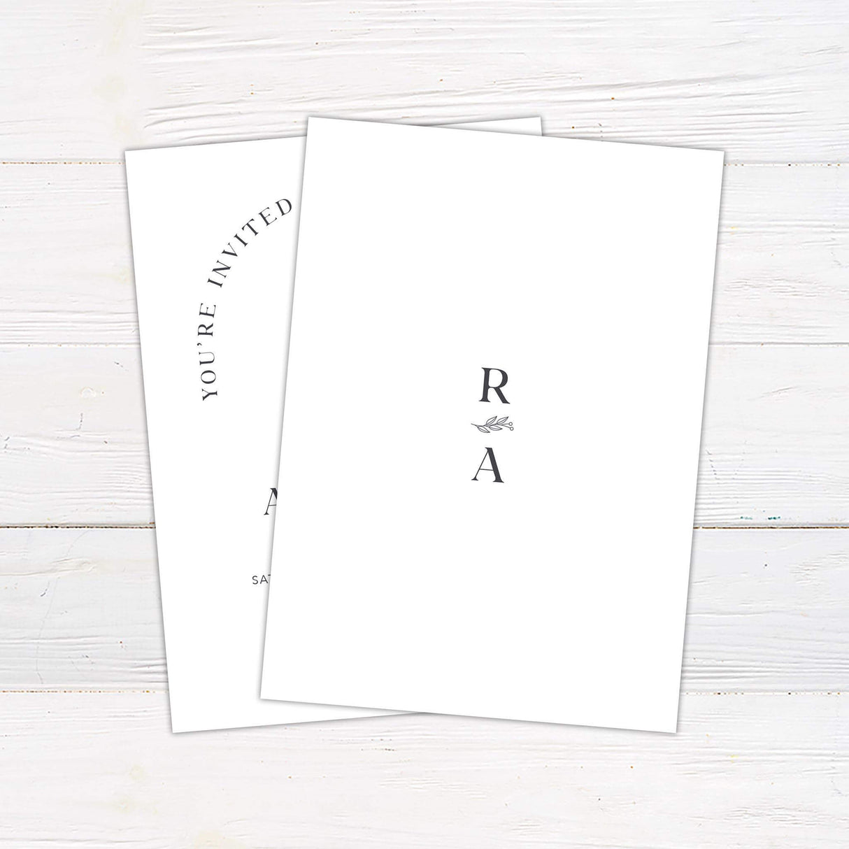 Minimalist monogram wedding invitation with botanical crest and arch layout in modern neutral tones - back side