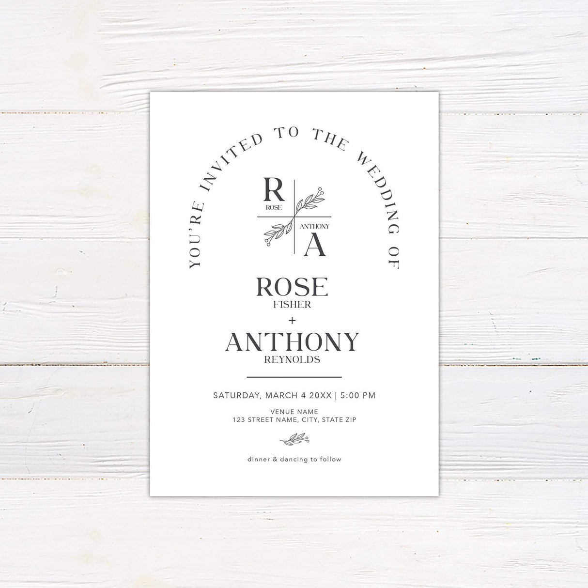 Minimalist monogram wedding invitation with botanical crest and arch layout in modern neutral tones