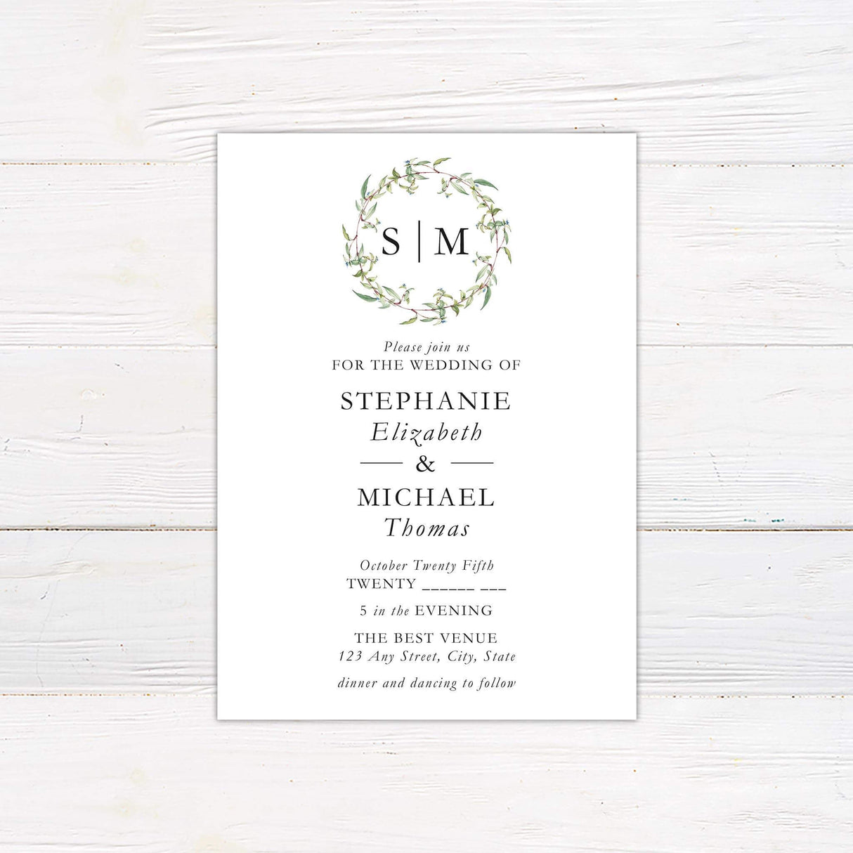 Minimalist wedding invitation with monogram wreath and botanical branch design in soft green tones