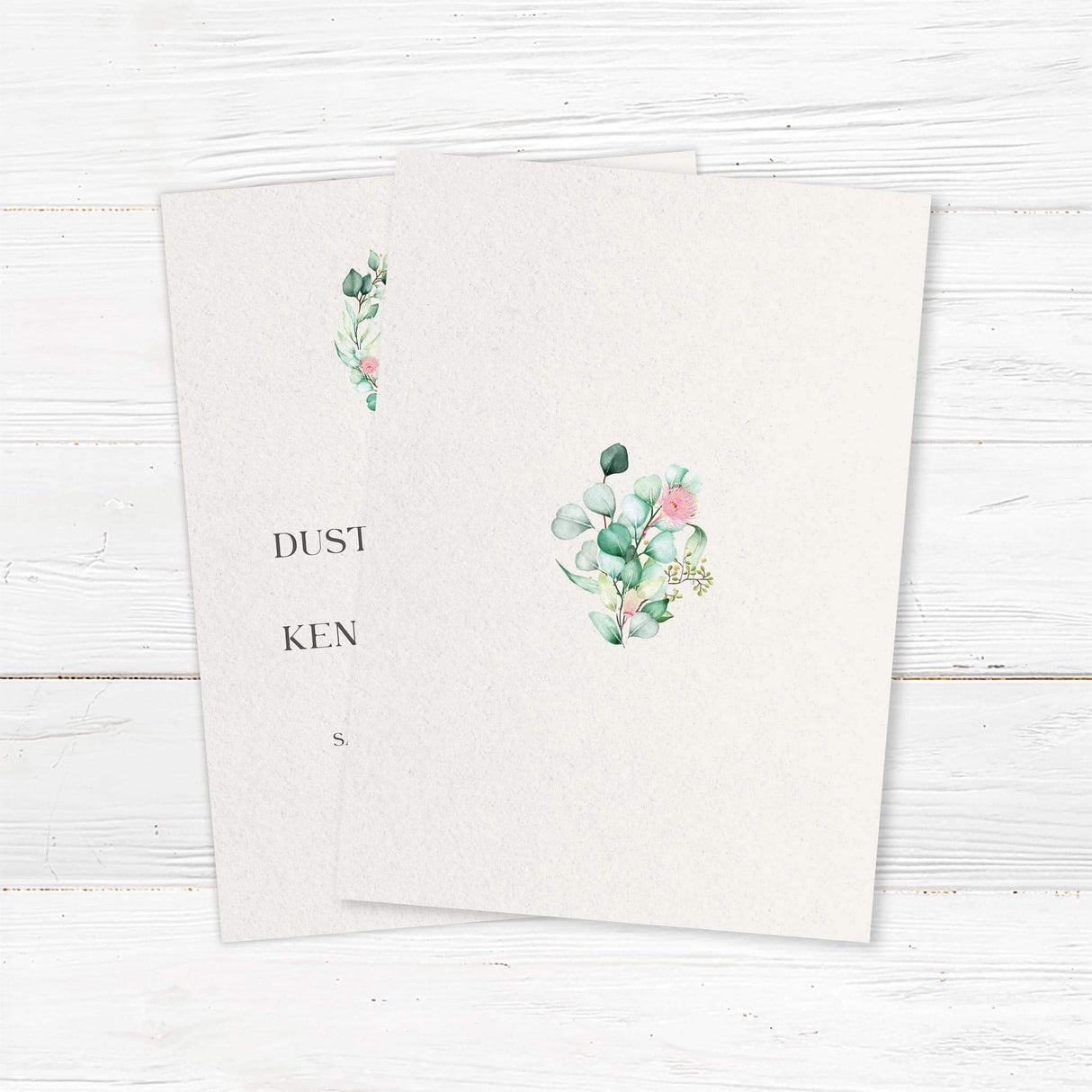 Wedding invitation with botanical wreath monogram, soft watercolor greenery, serif and script fonts on textured white paper - back