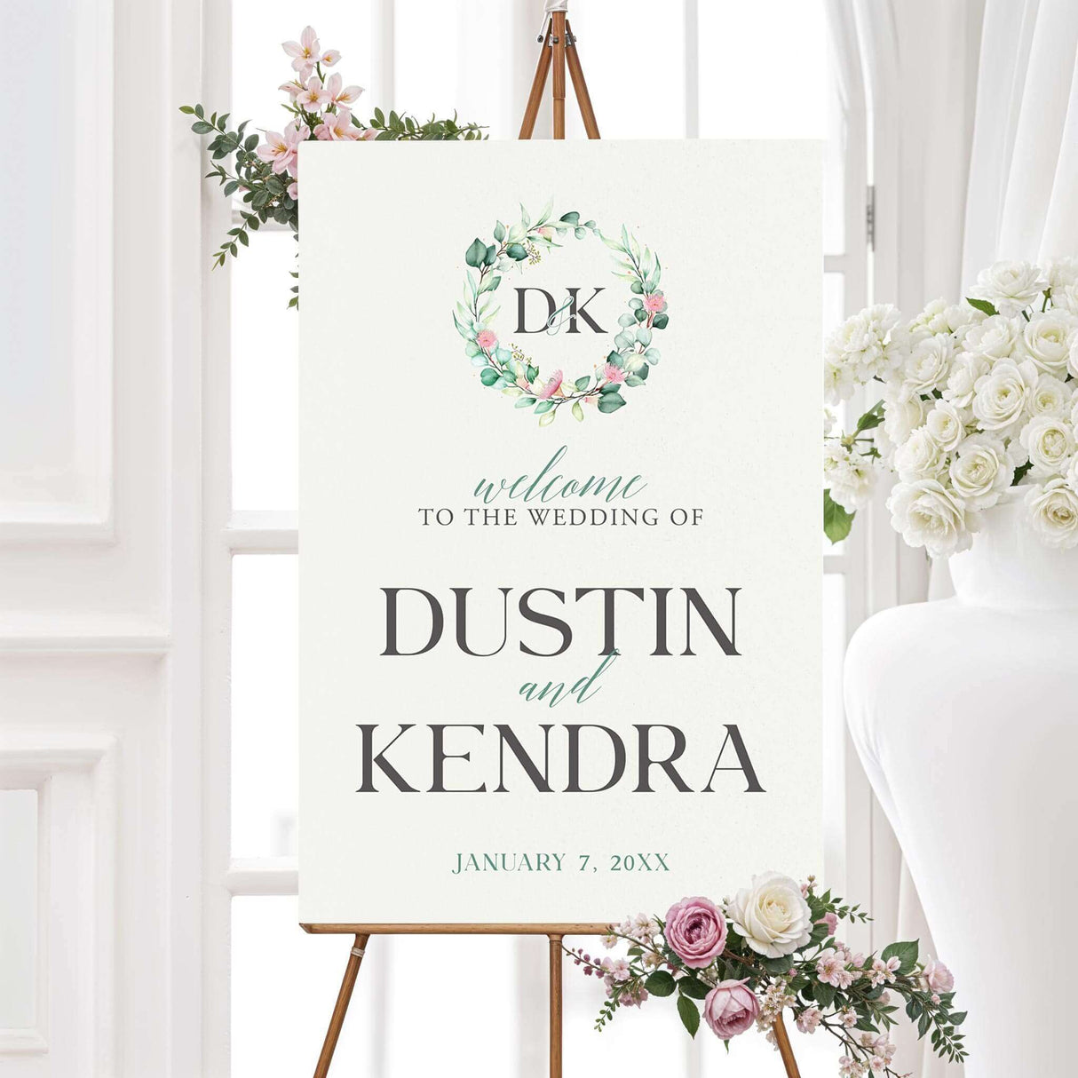 Wedding welcome sign with greenery wreath monogram and soft serif typography on ivory background