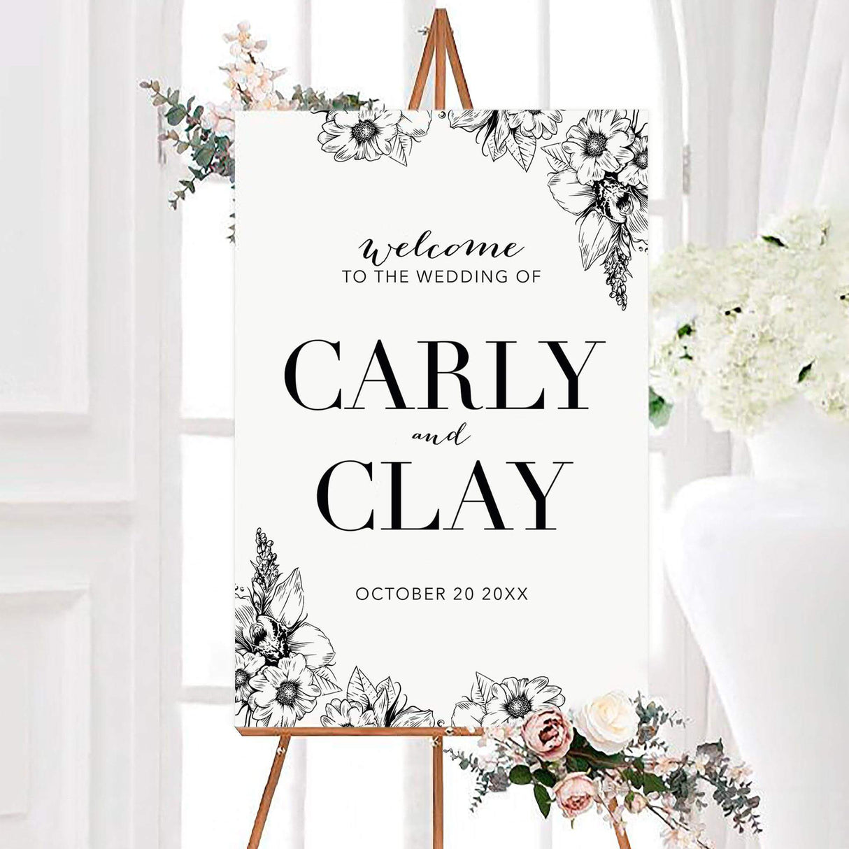 Black and white simply elegant personalized wedding welcome sign featuring detailed hand-sketched flowers and elegant typography. The design displays the couple’s names and wedding date surrounded by botanical floral illustrations.