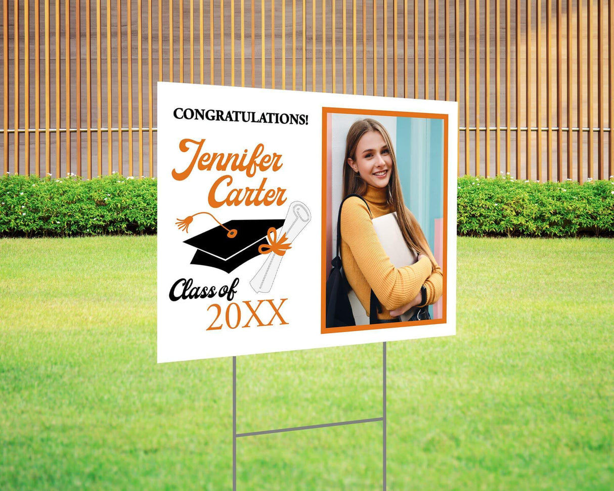 Congratulations graduation yard sign featuring a split design with a side photo, bold script name, mortarboard cap, and diploma graphic, along with the class year and school name in gold accents. Printed on durable Coreplast plastic, available in custom colors and single or double-sided print, perfect for high school and college graduates. orange and black
