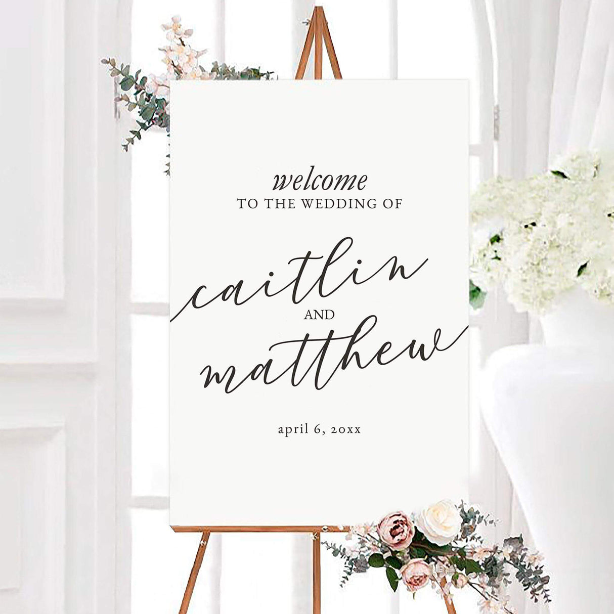Minimalist black and white slanted script wedding welcome sign featuring oversized slanted script names on a clean white background. The personalized design includes the couple’s names and wedding date in elegant black typography.