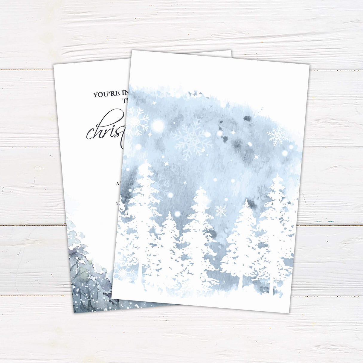 This is an elegant Christmas party invitation with calligraphy-style text and a soft wintery watercolor illustration of snow-covered trees at the bottom. The details of the event, such as date, time, venue, and RSVP information, are written in classic serif fonts. - back side.