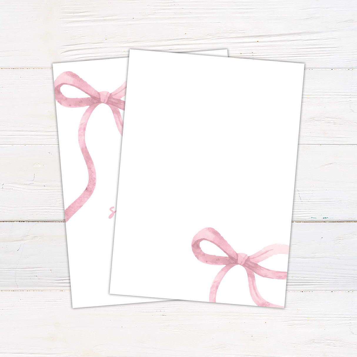 Elegant baby shower invitation with a soft pink watercolor ribbon design on a white background. Features delicate script and modern typography, perfect for celebrating the mom-to-be. Includes event details such as date, time, and location. A sophisticated and stylish choice for a baby girl shower. Back.