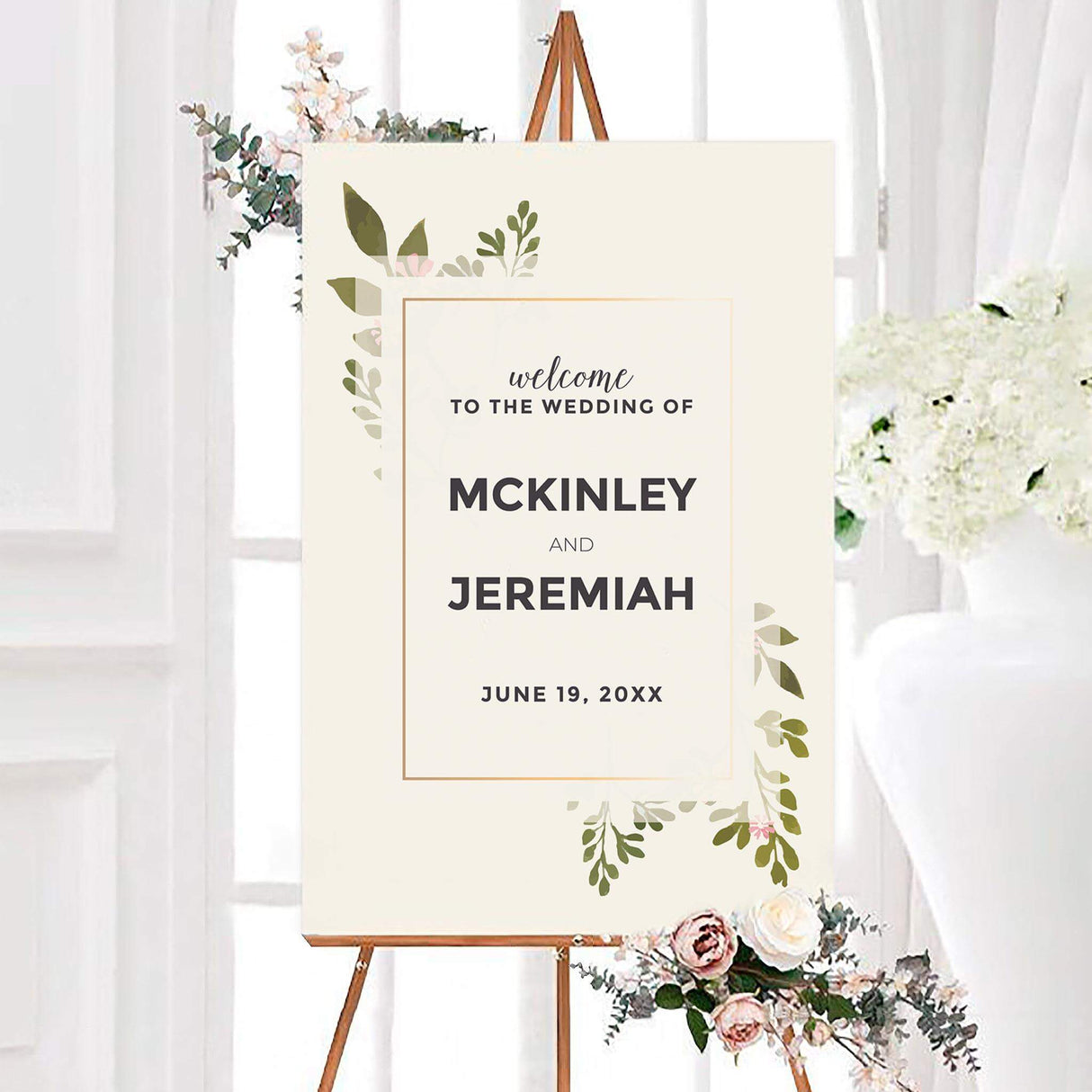 Modern soft touch wedding welcome sign with soft olive greenery, subtle blush flowers, and a thin gold border on an ivory background. Bold personalized names and the wedding date appear in dark charcoal lettering.