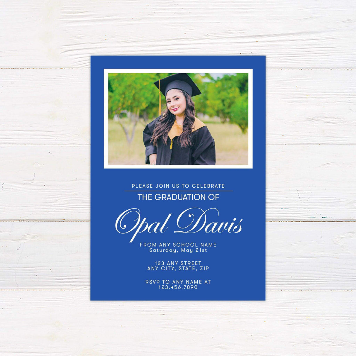 A customizable graduation invitation featuring a solid color frame design. The front includes a personalized photo at the top with the graduate’s name and event details below in an elegant script font. The back contains additional photos and a matching color scheme. The invitation color can be customized to coordinate with the school or event theme. Blue.