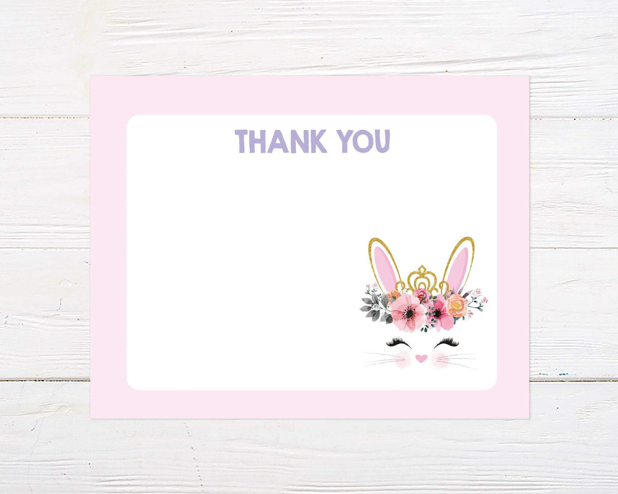 This thank you card features a cute bunny face with closed eyes, rosy cheeks, and a floral crown with gold glitter bunny ears and tiara. The background is light pink with "Thank You" written in purple at the top.