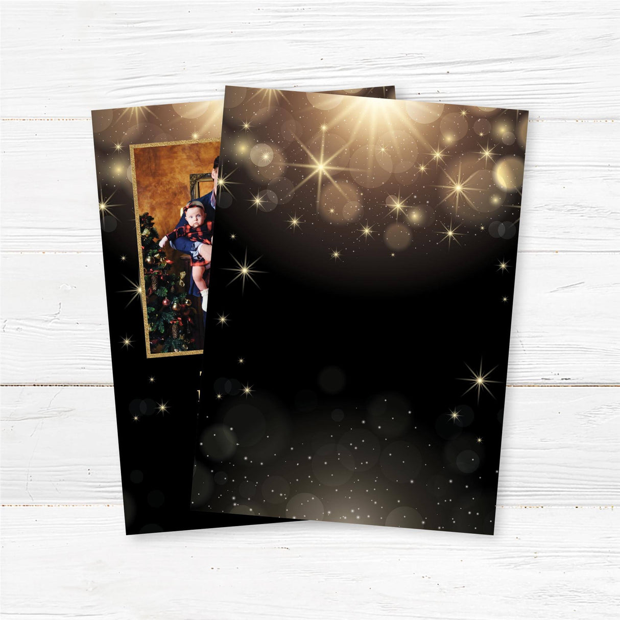 A personalized black and gold Christmas card featuring a family photo surrounded by sparkling lights and snowflakes. Includes festive holiday text and family greeting. back side