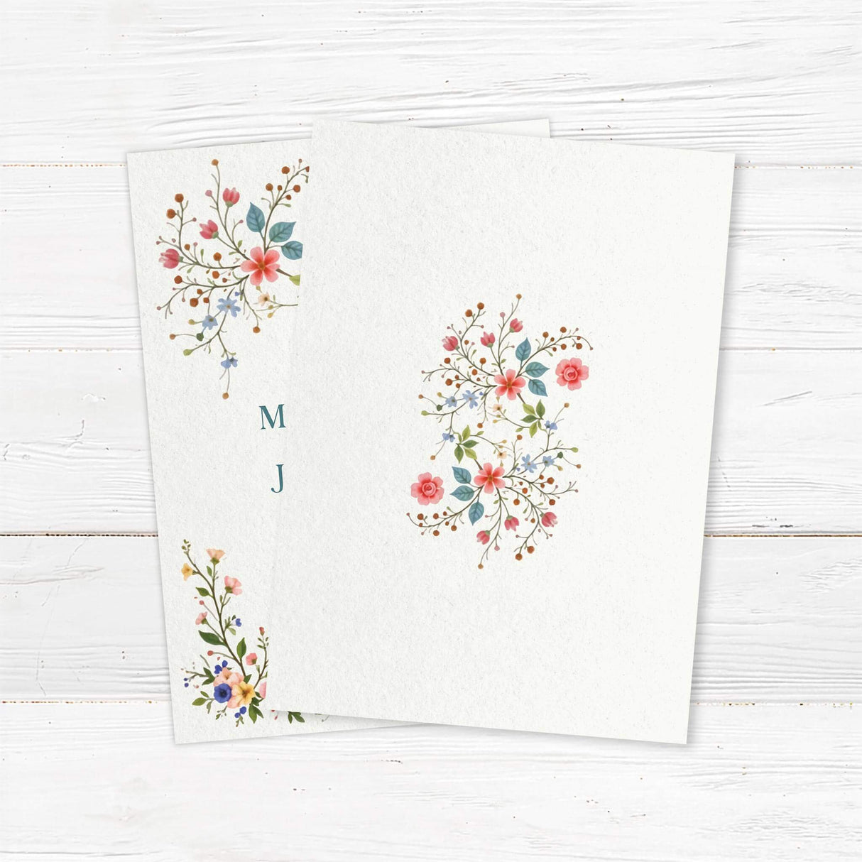 A wedding invitation with a soft cream background features an elegant floral design with pink, blue, and yellow flowers, green leaves, and delicate branches adorning the top and bottom. The text is styled in a mix of serif and script fonts, creating a romantic and timeless feel. Event details, including the date, time, and venue, are clearly displayed in a well-balanced layout. This design exudes classic elegance, perfect for a garden, vintage, or floral-themed wedding celebration. Back.