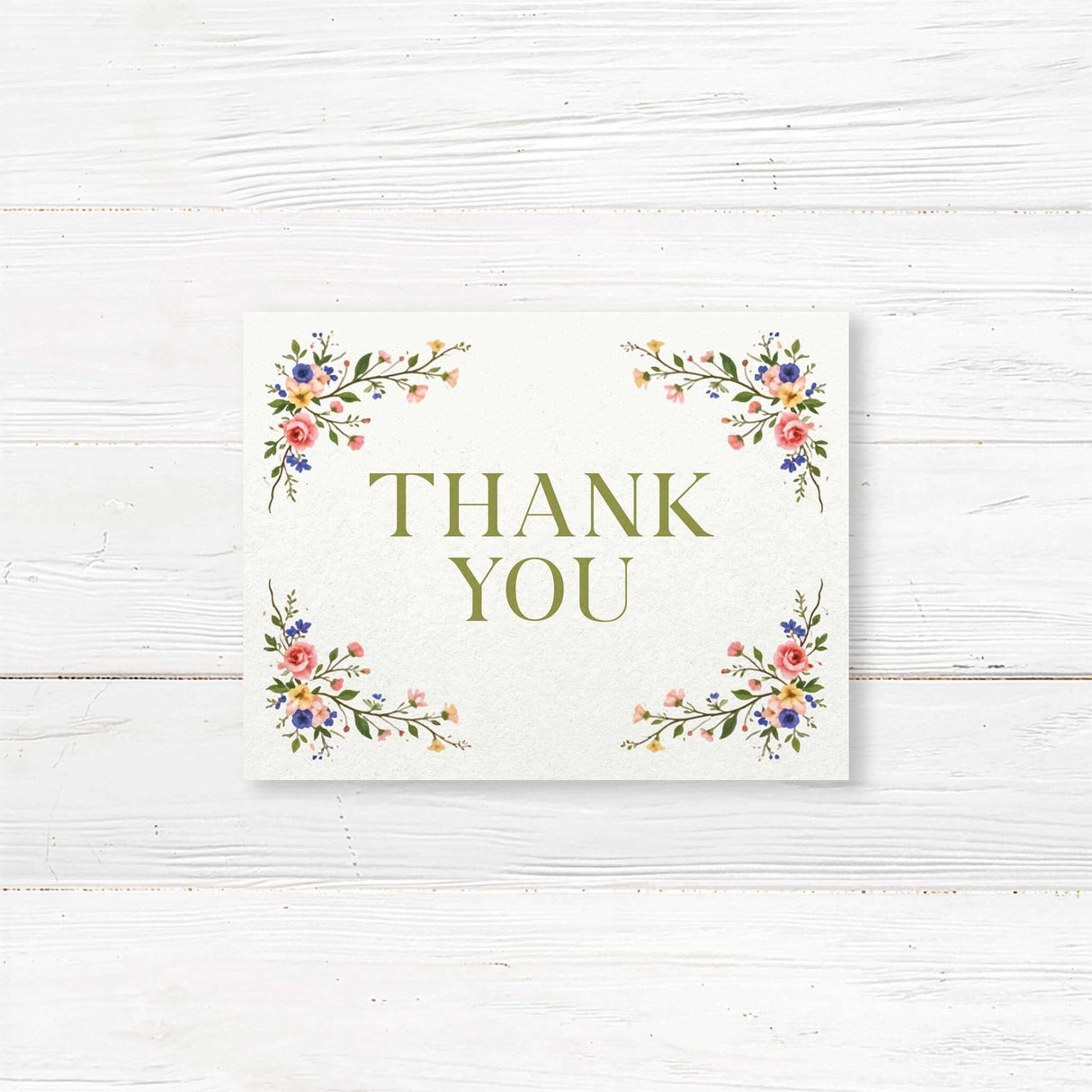 A thank you note card  with a background that features an elegant floral design with pink, blue, and yellow flowers, green leaves, and delicate branches adorning the top and bottom. The text is styled in a mix of serif and script fonts, creating a romantic and timeless feel. Event details, including the date, time, and venue, are clearly displayed in a well-balanced layout. This design exudes classic elegance.