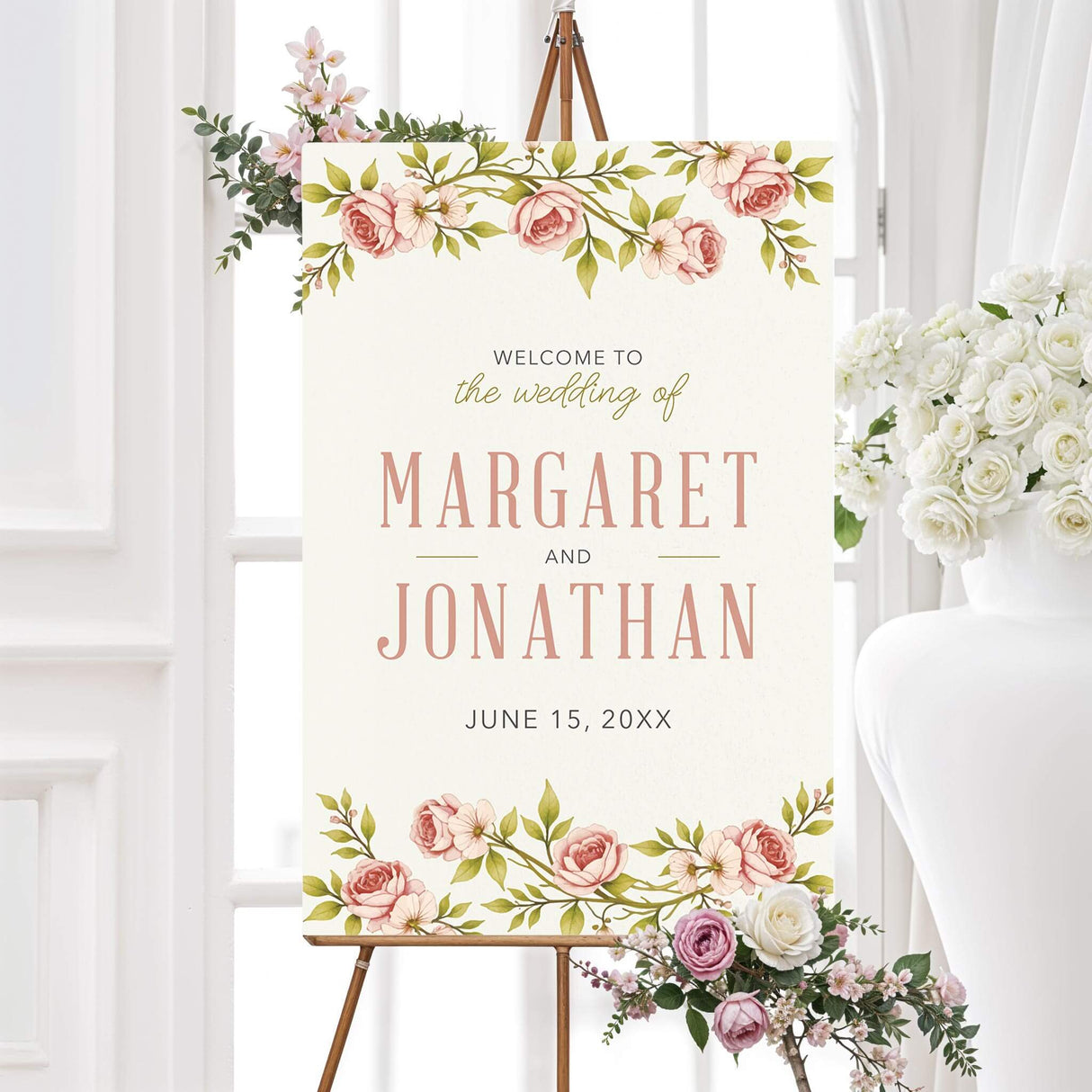 Blush pink spring vintage roses wedding welcome sign with watercolor flowers and fresh green botanical leaves on an ivory background. The personalized design features the couple’s names in large pink lettering with their wedding date below.