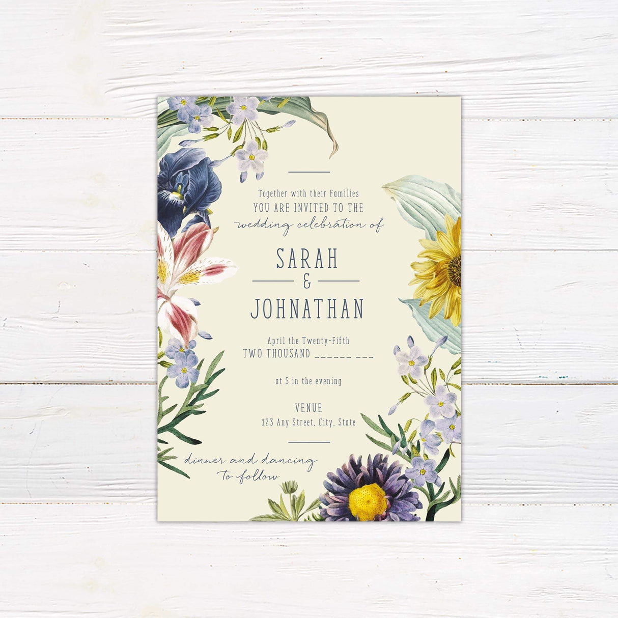 Watercolor spring wildflower wedding invitation featuring sunflowers, lilies, and forget-me-nots with elegant serif and script text.